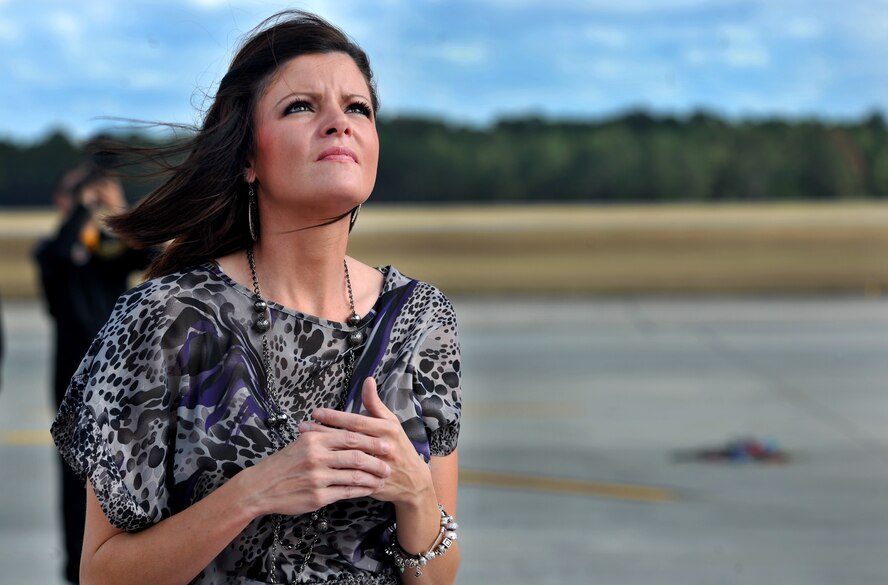 MOODY AIR FORCE BASE, Ga.-- Candise Thorpe, wife of Maj. Dylan Thorpe, A-10 East Demonstration Team pilot, looks to the sky as her husband maneuvers through the clouds during his certification flight Nov. 30. Maj. Thorpe’s family attended the flight and celebrated his new rank during the promotion ceremony. (U.S. Air Force photo/Airman 1st Class Joshua Green)(RELEASED)
