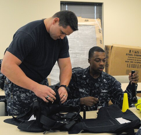 Master-at-Arms 2nd Class Nick Green, left, checks Auxiliary Security Force member Ship?s Serviceman 2nd Class James Ebron?s gear, ensuring all equipment is accounted for prior to standing post on Joint Base Charleston-Weapons Station, S.C., Nov. 29, 2010. U.S. Navy ASF members have been activated in order to provide assistance in force protection of Joint Base Charleston by manning entry control points and conducting vehicle inspections. MA2 Green works at the Security Department as the ASF coordinator at Naval Support Activity on JB CHS-WS. SH2 Ebron works at the Bachelor Enlisted Quarters at NSA on JB CHS-WS. (U.S. Navy photo/Mass Communication Specialist 1st Class Jennifer R. Hudson)