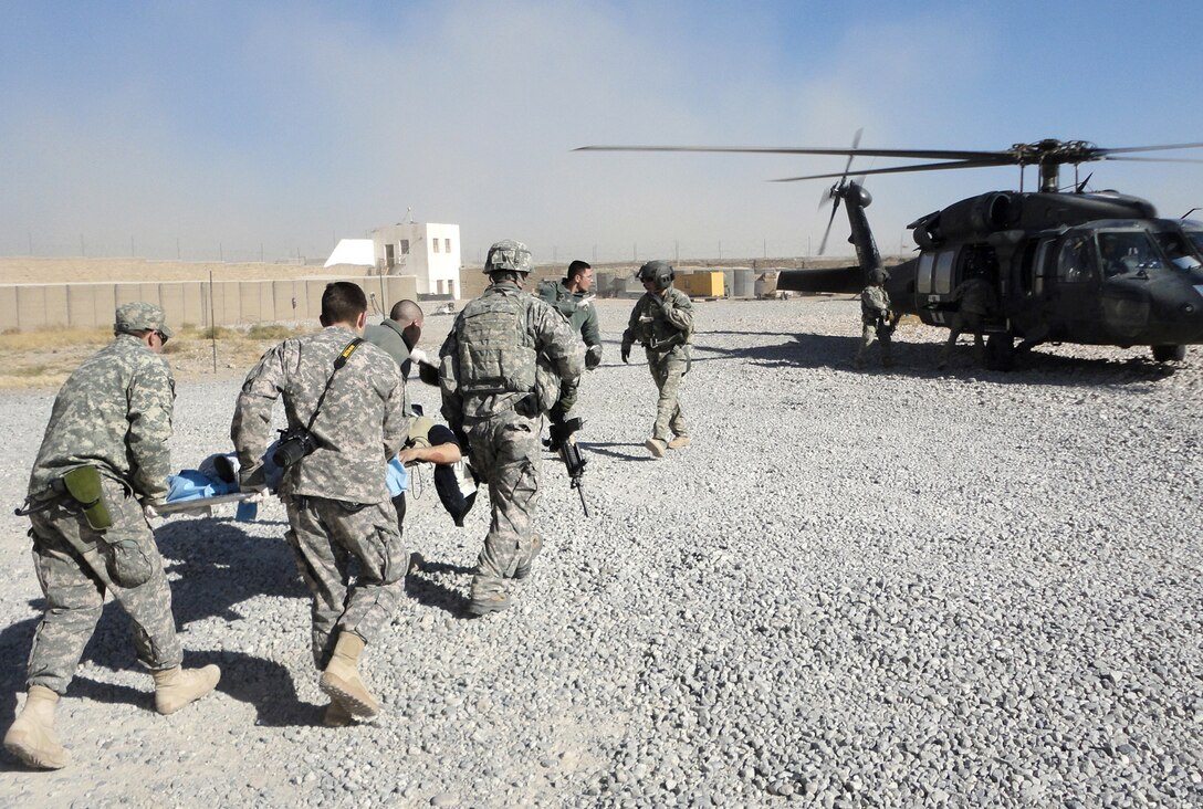 Airmen and Soldiers from Provincial Reconstruction Team Zabul load a patient onto a medevac helicopter after a civilian bus rolled over, leaving seven dead and more than 30 injured Nov. 30, 2010, just outside Qalat City, Afghanistan. Medical personnel from the PRT were on the scene at Zabul Provincial Hospital to assess patients and provide medical care. Nine patients with potentially life-threatening injuries were flown via helicopter from Forward Operating Base Smart to FOB Lagman, and then on to Kandahar. (U.S. Air Force photo/1st Lt. Brian Wagner) 