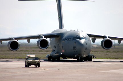 A C-17 Globemaster III from the 62nd Airlift Wing, on deployment from McChord Air Force Base, Wash., follows a High-Mobility Multipurpose Wheeled Vehicle transient alert vehicle to a parking spot during airfield operations at Karshi-Khanabad Air Base, Uzbekistan, on March 20, 2005, during Operation Enduring Freedom. (U.S. Air Force Photo/Master Sgt. Scott T. Sturkol)
