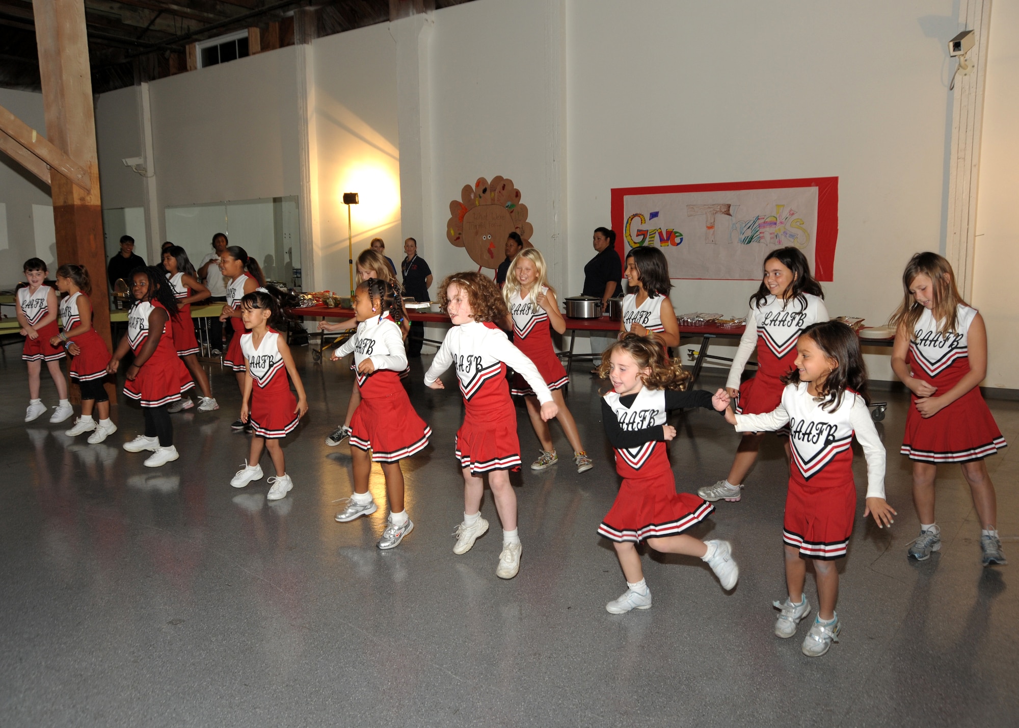 Coached by Amy Williams, the Los Angeles Drill Team made up of 5- to 7-year-olds, give an opening cheer at the Family Feast Pot Luck, Nov. 18.  Los Angeles Air Force Base, 61st Force Support Squadron and Youth Programs Office hosted the event to kick off the Thanksgiving holiday and provided ham and turkey to the many side dishes brought by family members. (Photo by Joe Juarez)

