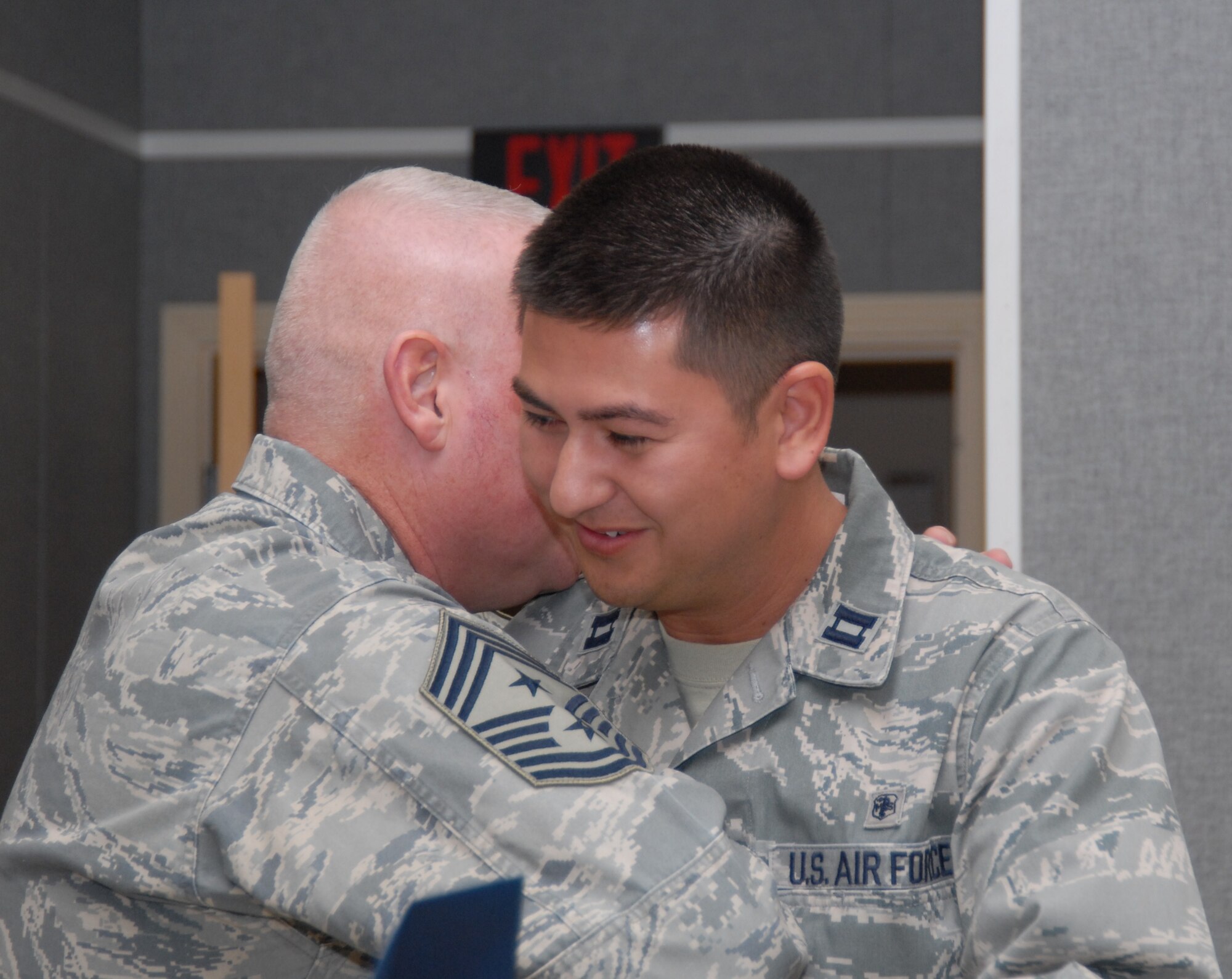 Chief Master Sgt. Bill Thomaston, 95th Air Base Wing command chief, embraces Capt. James Athnos, 95 MDSS, congratulating him on winning the Brig. Gen. Peter C. Belissario Young Health Care Administrator of the Year award. Twenty-two Air Force Materiel Command Medical Service Awards were presented to 95 MDG staff at the unit’s annual Thanksgiving Luncheon, Nov. 19. (Air Force Photo by Kate Blais)