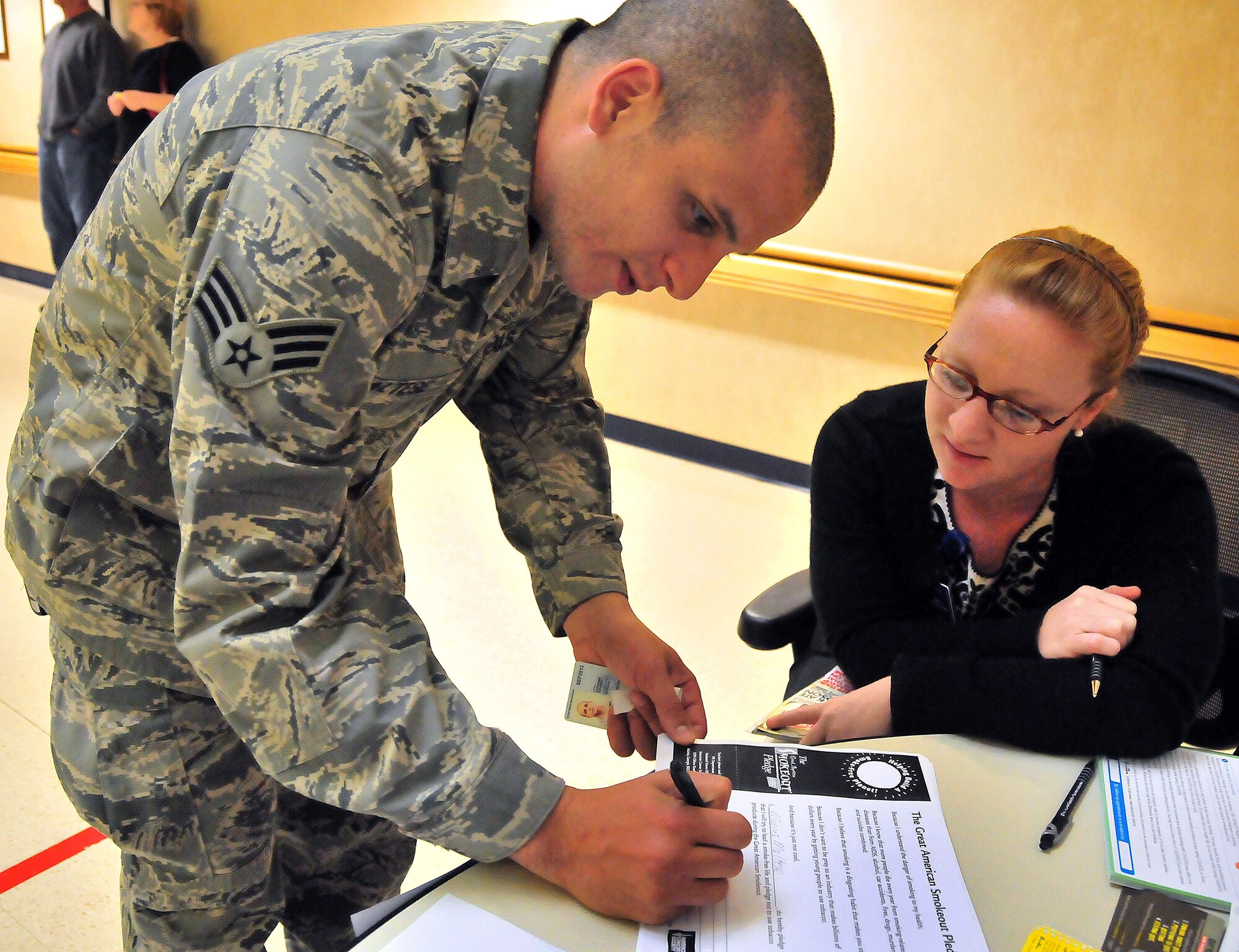 Senior Airman Marcus Maltese steps up for the Great American Smokeout pledge at the 628th Medical Group Clinic on Joint Base Charleston, S.C., Nov. 18, 2010. Combating the use of cancer causing tobacco products is the goal of the Great American Smokeout. It serves to spur active users to drop the habit for a full 24 hours, while providing information on treatment and support networks to aid in quitting for good. The Smokeout information booth at the Clinic was manned by Health and Wellness Center Dietician Greer Gowen. She and members of the HAWC staff provides a full spectrum of healthy living classes for the base, including those for tobacco cessation. (U.S. Air Force photo/Staff Sgt. Daniel Bowles)