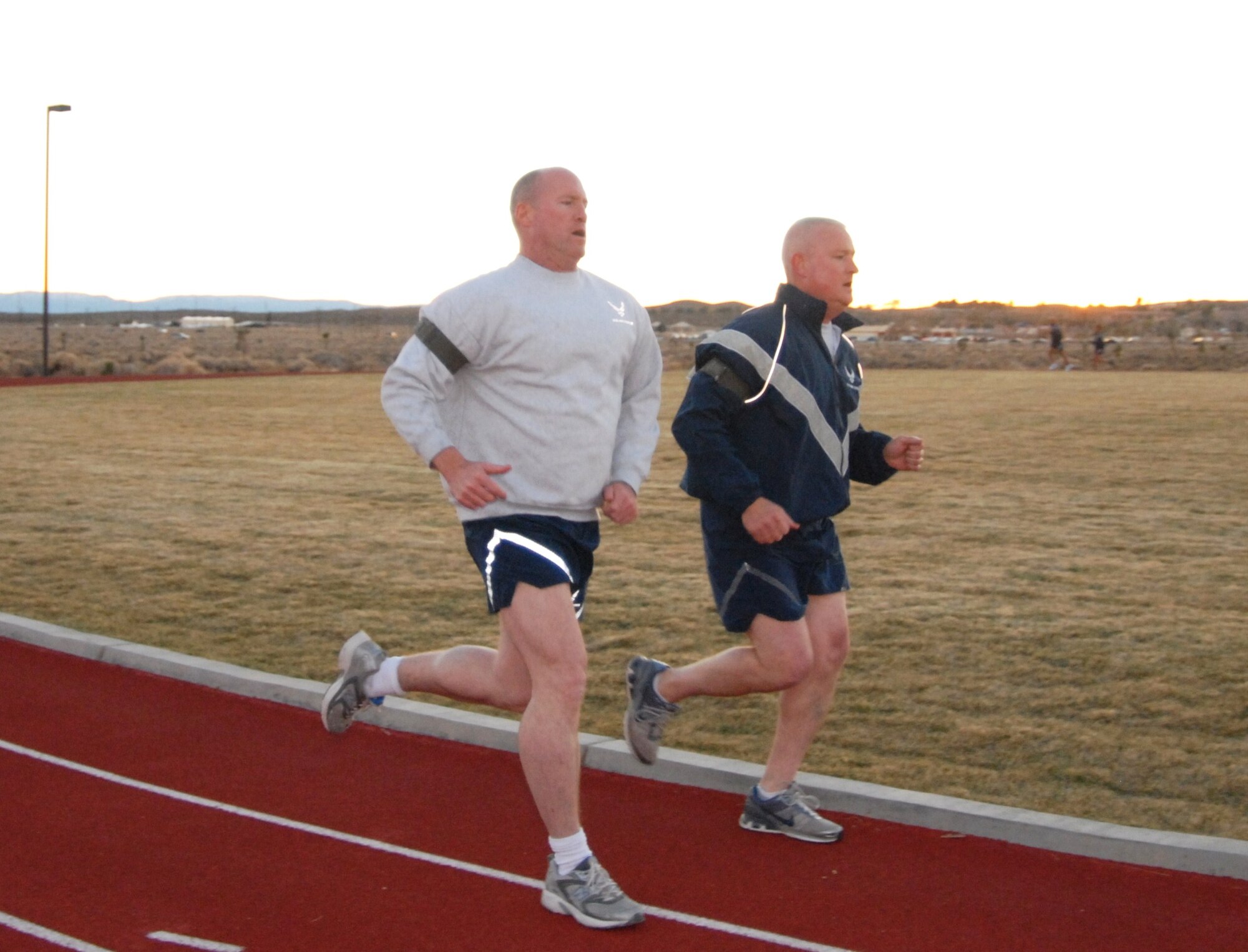 Brig. Gen. Robert C. Nolan II, Air Force Flight Test Center commander, performs the 1.5-mile run portion of his annual Air Force Physical Fitness Test while Chief Master Sgt. Bill Thomaston, 95 Air Base Wing command chief, runs alongside. General Nolan scored a 95 on his fitness test Nov. 29. The AFFTC commander wants every Airman at Edwards to be “Fit to Fight.” The new Air Force Fitness Program increases the responsibility for Airmen to maintain year-round physical fitness. Healthy, fit lifestyles greatly benefit Airmen and the Air Force both now and in the future. General Nolan encourages all Airmen and Edwards civilians to embrace the fitness culture. (Air Force photo by Kenji Thuloweit)