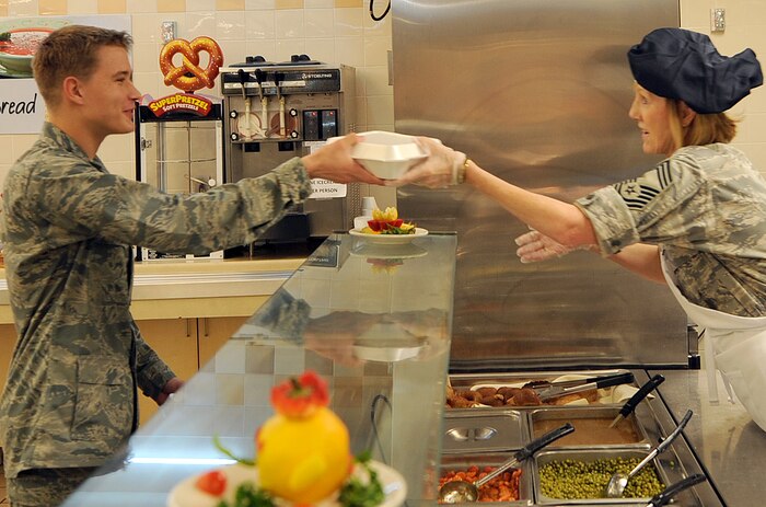 Chief Master Sgt. Ann Hamilton serves Airman Andrew Finley a plate of food during the Thanksgiving dinner held at the Robert D. Gaylor Dining Facility on Joint Base Charleston, S.C., Nov. 25, 2010. The dinner included roast beef, roast turkey, baked ham, sweet potatoes. mashed potatoes, cornbread dressing, rice, green beans with mushrooms, corn, peas, carrots and assorted deserts. Chief Hamilton is with the 315th Aerospace Medicine Squadron, and Airman Finley is attending C-17 crew chief technical school with the 373rd Training Squadron. (U.S. Air Force photo/Tech. Sgt  Chrissy Best)