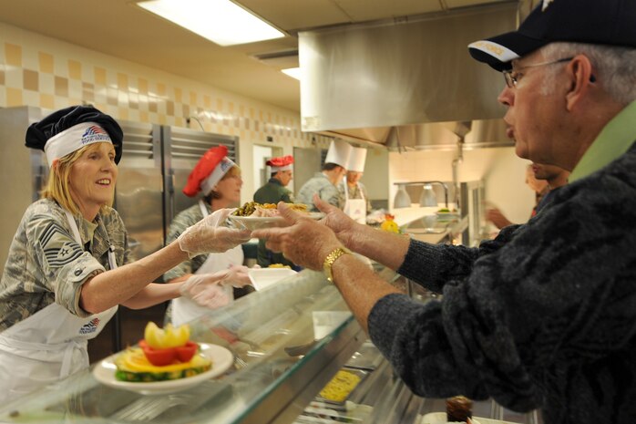 Chief Master Sgt. Ann Hamilton serves Chief Master Sgt. (Ret.) John Green a plate of food during the Thanksgiving dinner held at the Robert D. Gaylor Dining Facility on Joint Base Charleston, S.C., Nov. 25, 2010. A traditional Thanksgiving dinner with turkey, ham and all the fixings were served to active-duty military, retirees and their families. Chief Hamilton is with the 315th Aerospace Medicine Squadron, and Chief Green retired from the Air Force after 30 years of service. (U.S. Air Force photo/Tech. Sgt  Chrissy Best)