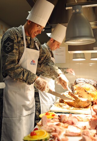 Chief Master Sgt. Terrence Greene slices a turkey while Maj. David Joerres, right, slices roast beef to serve Thanksgiving dinner at the Robert D. Gaylor Dining Facility on Joint Base Charleston, S.C., Nov. 25, 2010. A traditional Thanksgiving dinner with turkey, ham and all the fixings were served to active-duty military, retirees and their families. Major Joerres is the 628th Communications Squadron commander, and Chief Greene is the 437th Airlift Wing command chief. (U.S. Air Force photo/Tech. Sgt  Chrissy Best)