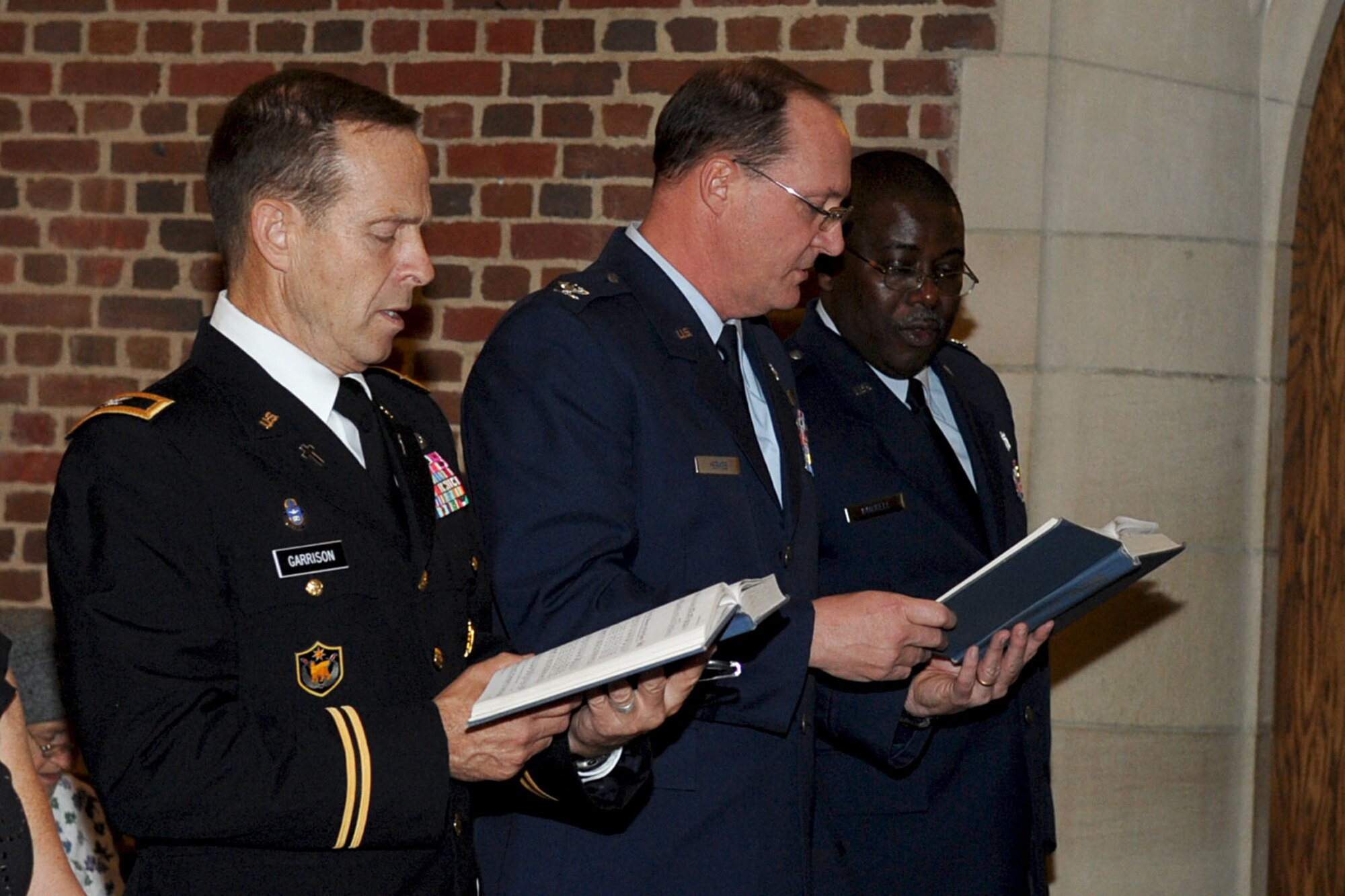 LANGLEY AIR FORCE BASE, Va. -- Joint Base Langley-Eustis Chaplains (Col.) Richard Garrison, (left), (Col.) Frank Yerkes and (Lt. Col.) Bill Berrell read a scripture during the Ecumenical Thanksgiving Service at the Langley Chapel Nov. 23. The event marked the first joint Thanksgiving service held by the Wing chaplains. (U.S. Air Force photo/Staff Sgt. Ashley Hawkins)(RELEASED)