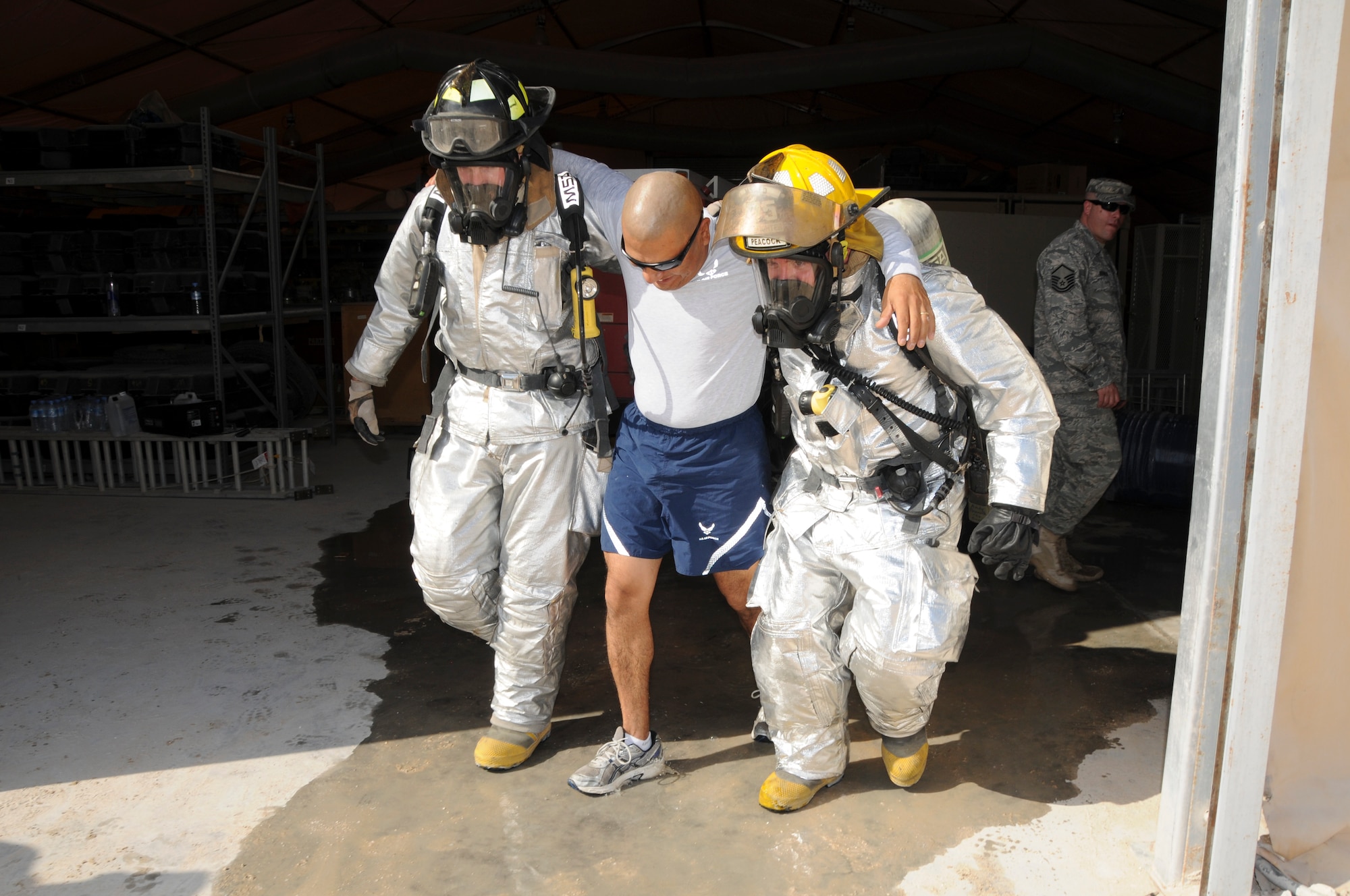 SOUTHWEST ASIA - Senior Airman James Demmeritt, left, and Airman First Class Paul Rea assist a simulated casualty from a contamination scene here Oct. 28, during an interoperability exercise. (U.S. Air Force photo/Tech. Sgt. Kimberly Spinner)