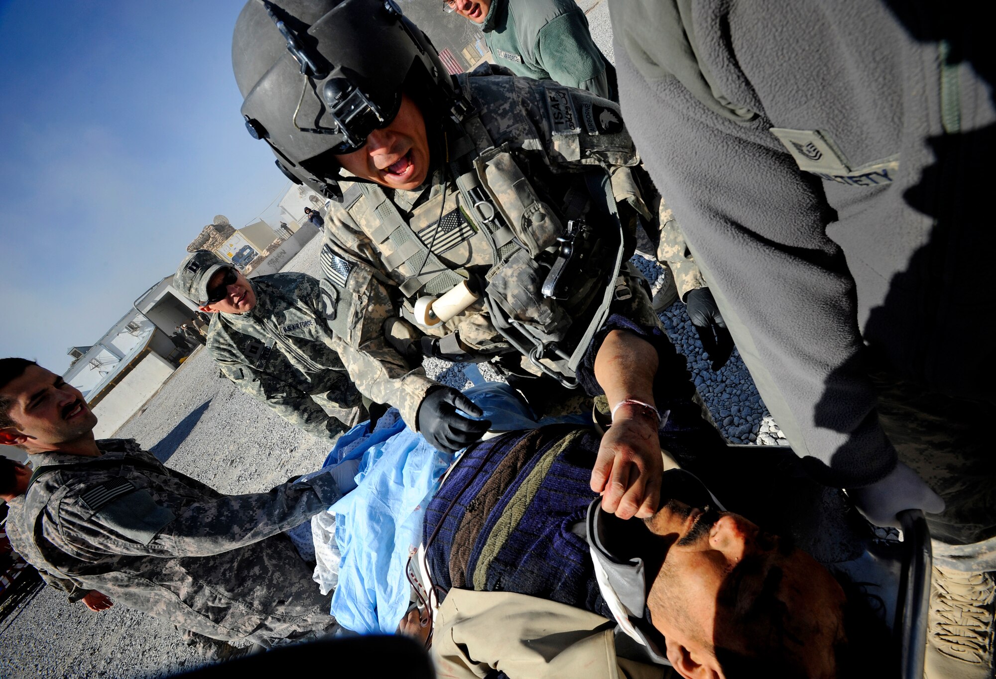 A flight medic assesses a patient at Forward Operating Base Smart, Afghanistan, before loading him onto a medevac helicopter, Nov. 30. A civilian bus headed south on Highway 1 rolled over leaving seven dead and more than 30 injured just outside Qalat City. Medical personnel from Provincial Reconstruction Team Zabul were on the scene at Zabul Provincial Hospital to assess patients and provide medical care. Nine patients with potentially life-threatening injuries were flown via helicopter from Forward Operating Base Smart to FOB Lagman, and then on to Kandahar.  (U.S. Air Force photo by Staff Sgt. Brian Ferguson/Released)


