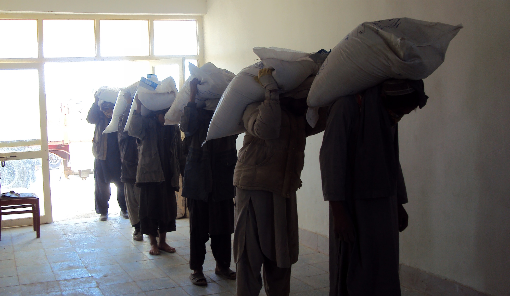 Afghans off-load wheat seed from a truck upon delivery to Qalat City, Zabul province, Afghanistan, Nov. 25. The seed is being delivered to supply farmers for the winter planting season, part of the National Seed Distribution Program. The seed will benefit 260,000 farmers in 31 of Afghanistan's 34 provinces. (U.S. Air Force photo by Staff Sgt. Brian Ferguson/Released)


