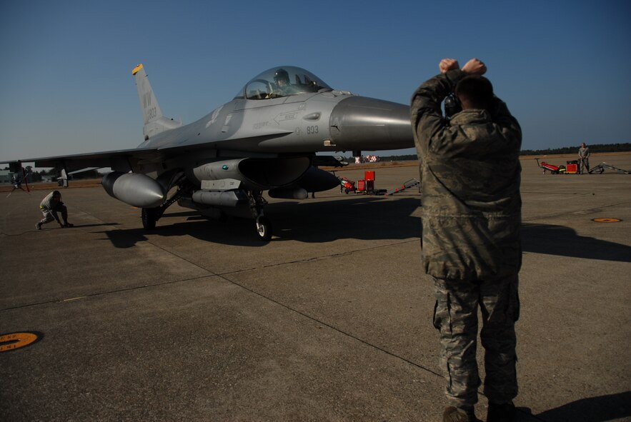 U.S. Air Force Staff Sgt. Jason Holubik, 35th Aircraft Maintenance Squadron crew chief, marshals an F-16 Flying Falcon on the Komatsu Air Base, Japan runway Dec. 1, 2010. Sergeant Holubik is among more than 160 Airmen from Misawa AB Japan, who have travelled to Komatsu in support of the biennial KEEN SWORD exercise scheduled Dec. 3 through 10. (U.S. Air Force photo by 1st Lt. Cammie Quinn/Released)
