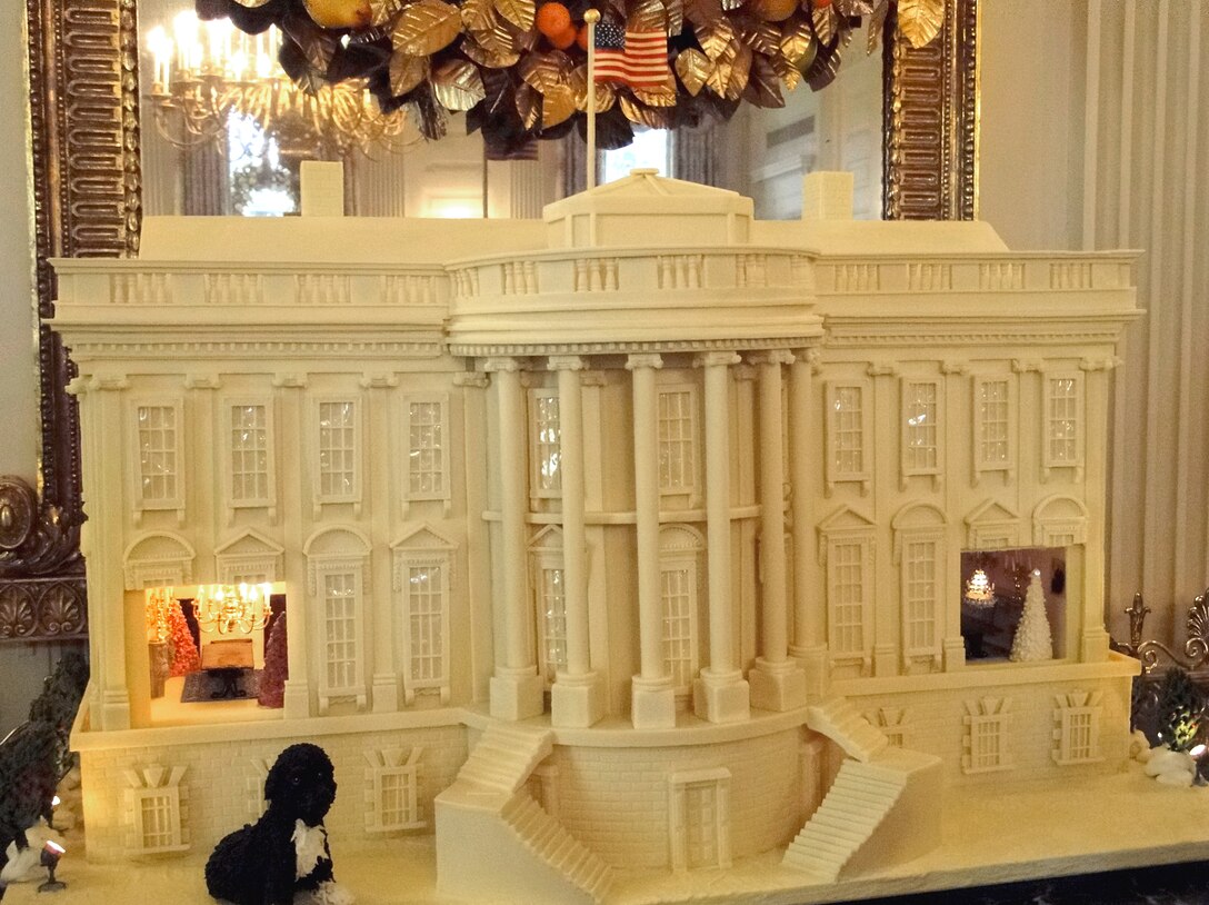 A 390-pound, white chocolate and gingerbread replica of the White House, with an oversized semblance of First Dog Bo adorns the East Room of the White House where First Lady Michelle Obama decorated Christmas cookies and crafts with military children, Washington, D.C., Dec. 1, 2010.