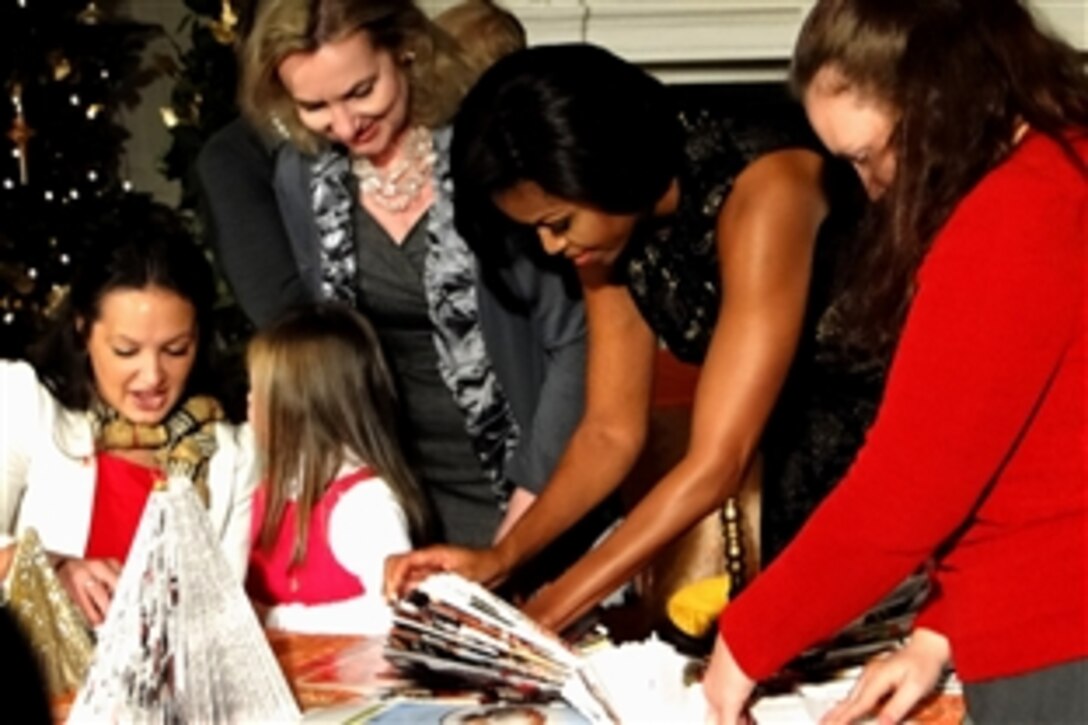 First Lady Michelle Obama works with military children and White House decorators to create Christmas trees made of recycled paper, Dec. 1, 2010, Washington, D.C. The First Lady welcomed Marine Corps families to the White House for an event that highlighted the Marine Corps Reserve charity Toys for Tots and allowed military children to makes holiday crafts with the first lady, Dec. 1, 2010, Washington, D.C. 