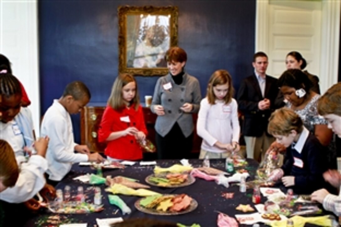 Sheila Casey, wife of Army Chief of Staff Gen. George W. Casey Jr., helps children decorate cookies at a holiday event hosted by Dr. Jill Biden, wife of Vice President Joe Biden, at their home at the Naval Observatory, Washington, D.C., Dec. 1, 2010. Dr. Biden invited 25 children whose parents are local National Guard members and 25 from local schools.