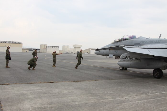 Marines from Marine All-Weather Fighter Attack Squadron 225 ordnance wait for the aircraft to stop so they can secure the ordnance that they put on the aircraft during the Wolmi-Do Fury exercise here Dec. 2, 2010. The ordnance Marines are placed with the job of prepping, arming, disarming and::r::::n::loading the ordnance onto the aircraft when the aircraft is needed to be armed and ready.