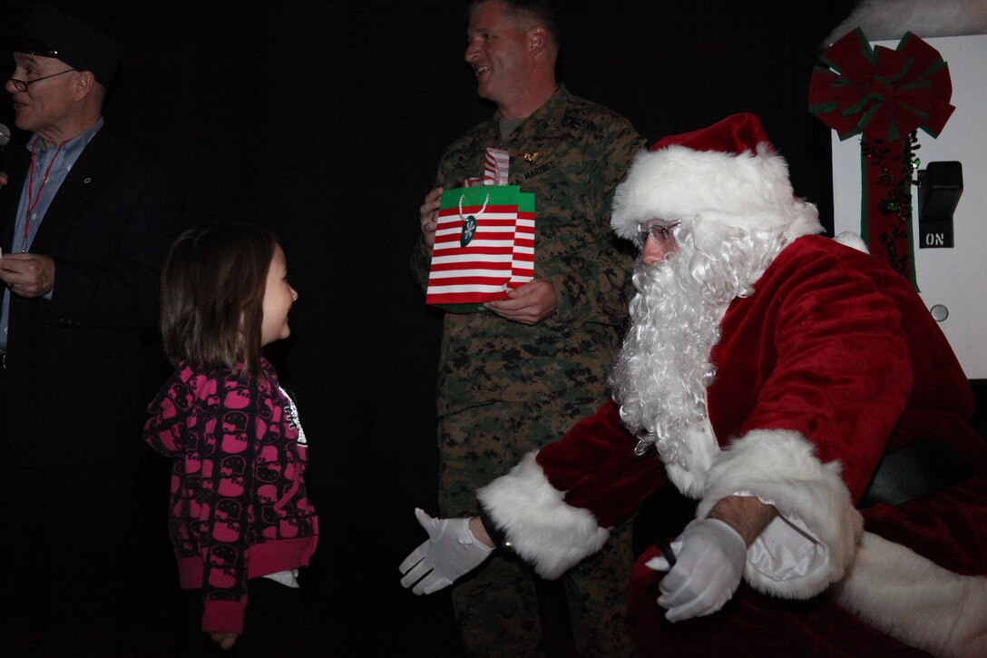 Santa Claus opens his arms for a hug from a little girl during the Marine Corps Community Services Family Christmas Event at the Cherry Point theater Dec. 2. The free event lasted about three hours and helped lift the holiday spirits for those who may not be able to make it home this year.