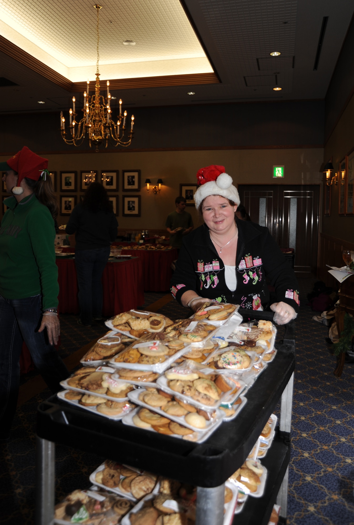 Janet Niemi pushes a treat-laden cart at Misawa Air Base's Annual Cookie Caper. More than 100 volunteers packaged home backed cookies and sweets for single and unaccompanied service members stationed here. Volunteers from around the base prepared more than 16,000 cookies for this annual event. (U.S. Navy photo by Mass Communication Specialist 1st Class Matthew M. Bradley)