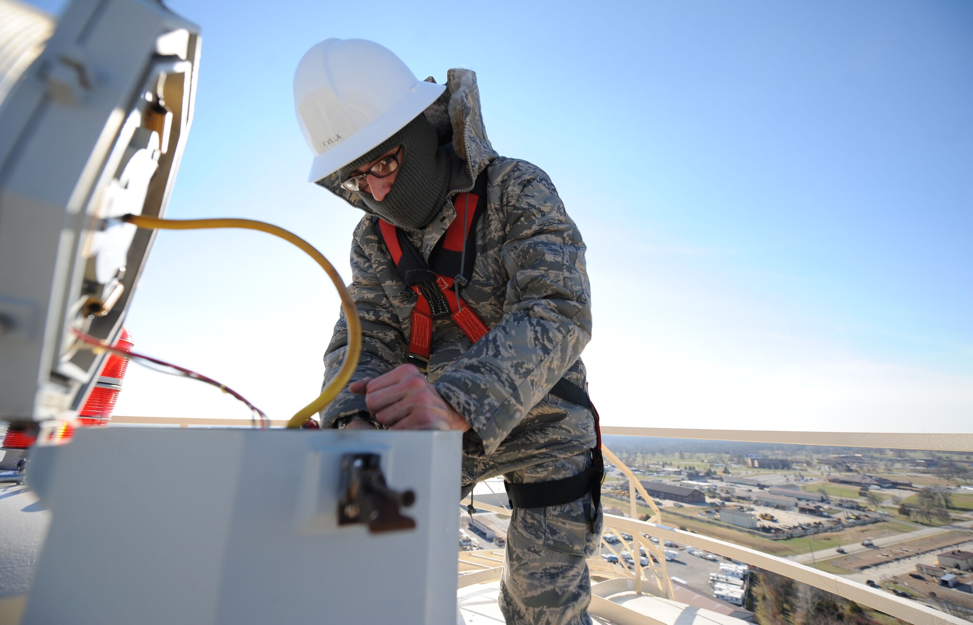 WHITEMAN AIR FORCE BASE, Mo. - Airman 1st Class Francisco Villa, 509th Civil Engineer Squadron electricians, completes preventive maintenance on airfield equipment on top of the 215-foot base water tower, Dec. 1. (U.S. Air Force photo by Senior Airman Carlin Leslie) (Released)
