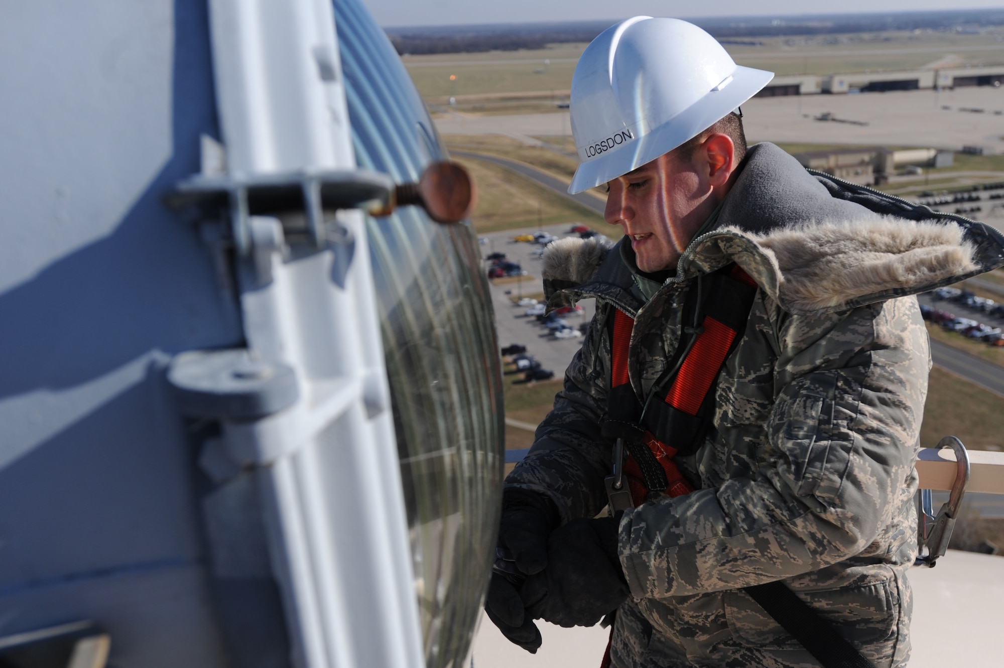WHITEMAN AIR FORCE BASE, Mo. - Airman 1st Class Corey Logsdon, 509th Civil Engineer Squadron electrician, detaches clamps from the beacon light atop the base water tower, Dec. 1. Airman Logsdon checks and inspects lights for any required maintenance. (U.S. Air Force photo by Senior Airman Carlin Leslie) (Released)