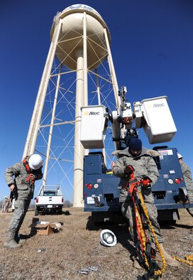 WHITEMAN AIR FORCE BASE, Mo. - Airman 1st Class Francisco Villa and Corey Logsdon, 509th Civil Engineer Squadron electricians, put on safety harnesses, hard hats and cold-weather gear to climb a 215-foot water tower , Dec. 1. Airman Villa and Airman Logsdon serviced the rotating beacon and tower lights for flight safety. (U.S. Air Force photo by Senior Airman Carlin Leslie) (Released)
