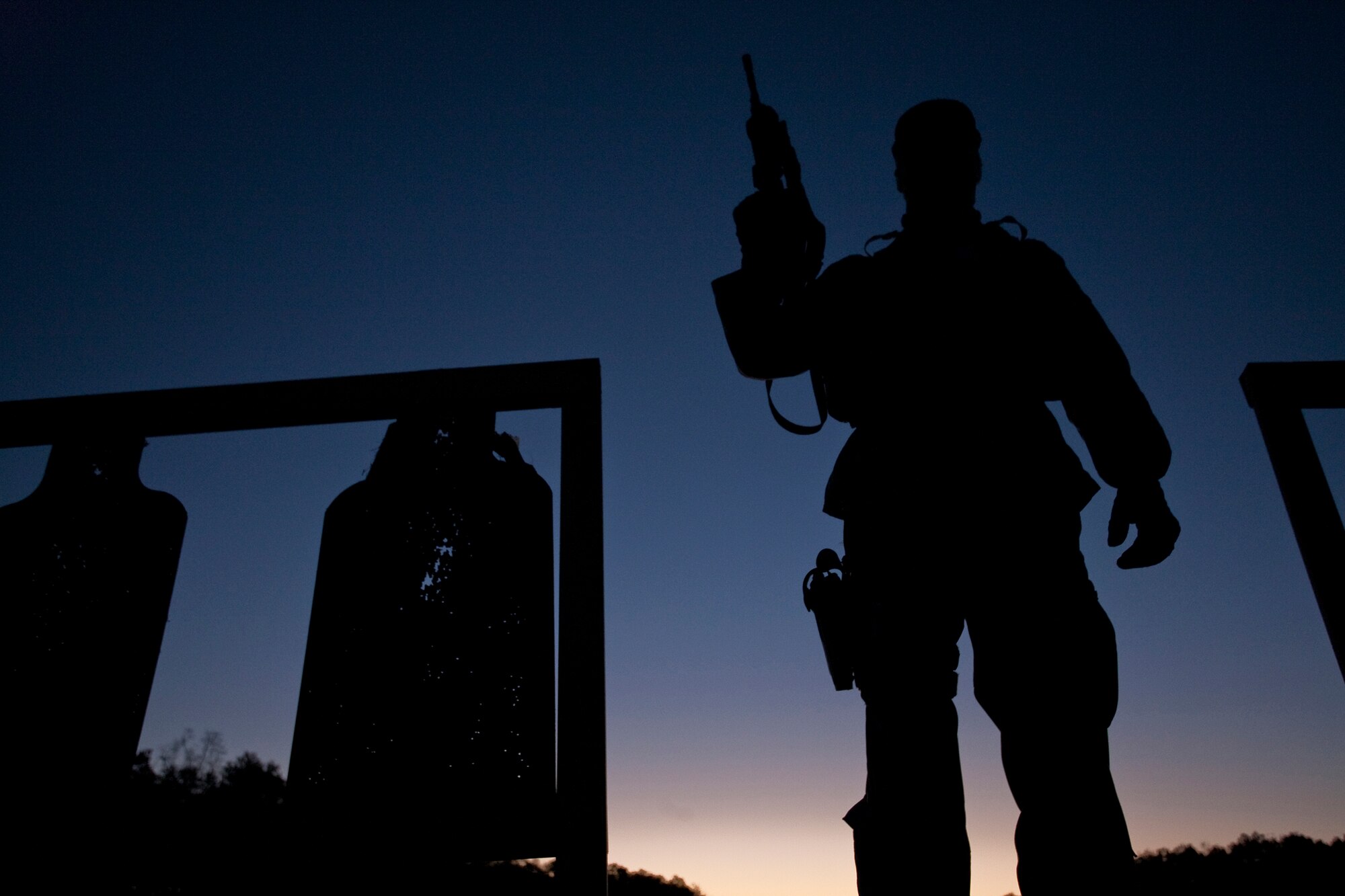 Senior Airman Mason Flores takes a moment to survey the scene in the pre-dawn light after preparing targets for upcoming M-4 rifle qualifications. The 138th Security Forces Squadron deployed from Tulsa, Okla., to Fort Chaffee, Ark., for weapons training and qualifications in preparation for an upcoming assignment. Airman Flores is with the 138th SFS. (U. S. Air Force photo/Master Sgt. Mark A. Moore)
