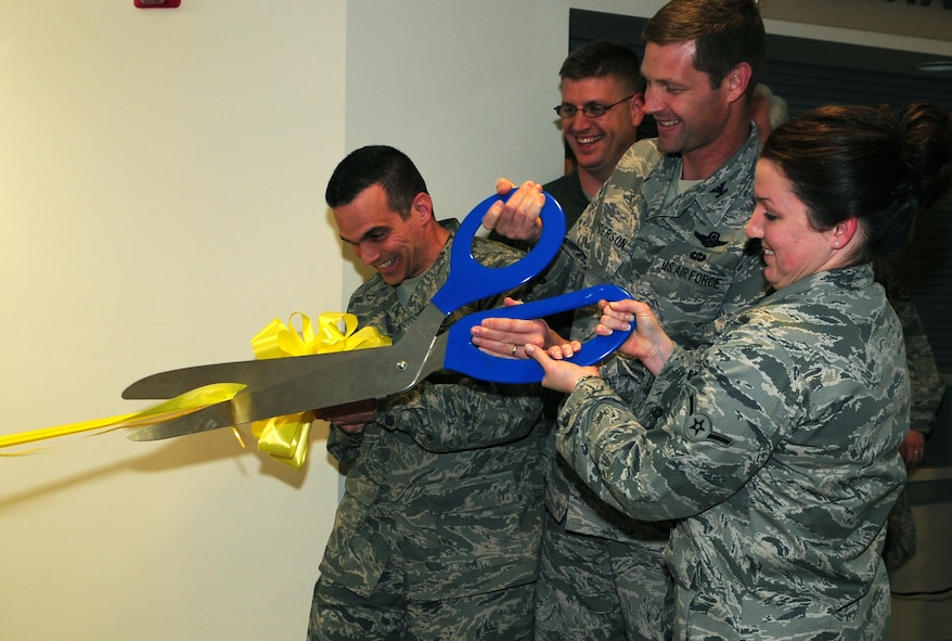 MOODY AIR FORCE BASE, Ga.-- Col. Gary Henderson, 23rd Wing commander, and Airman Lee Sandebeck, 23rd Aerospace Medicine Squadron, cut the ribbon during the dental clinic expansion opening Dec. 3. The expansion allows the dental clinic to fully utilize all eight credentialed dentists because they will each have their own room to practice in. (U.S. Air Force photo/Senior Airman Stephanie Mancha)(RELEASED)