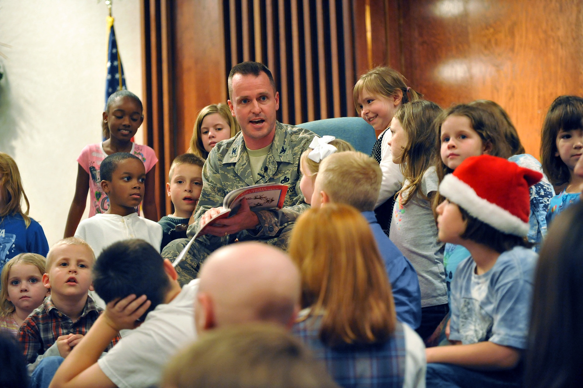 Col. Carl Buhler, 78th Air Base Wing commander, reads "T'was the night before Christmas" to a group of Robins children. U. S. Air Force photo by Tommie Horton