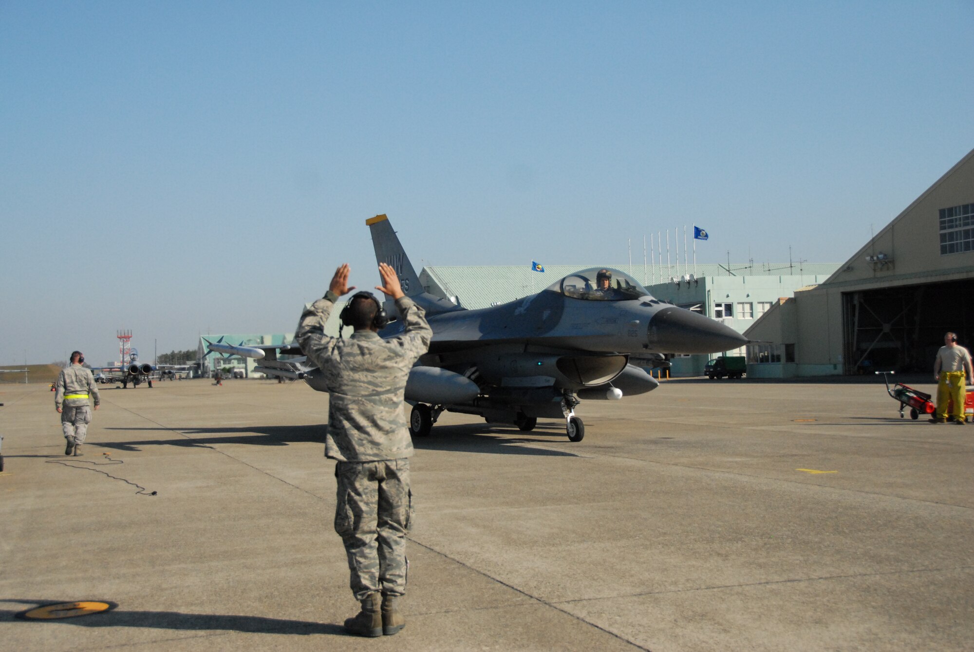 U.S. Air Force Senior Airman Andy Irizarry, an aircraft crew chief from the 35th Aircraft Maintenance Squadron, marshals Lt. Col. Steve Jantz, 14th Fighter Squadron director of operations at Misawa Air Base, Japan, as he lands at the Komatsu Air Base, Japan, runway in support of Keen Sword 2011 on Dec. 1, 2010. Keen Sword is a week-long exercise which provides an environment for enhancing a mutual understanding of American and Japanese tactics, communication protocols, and general operability. (U.S. Air Force photo by Capt. Strysan Murrell)