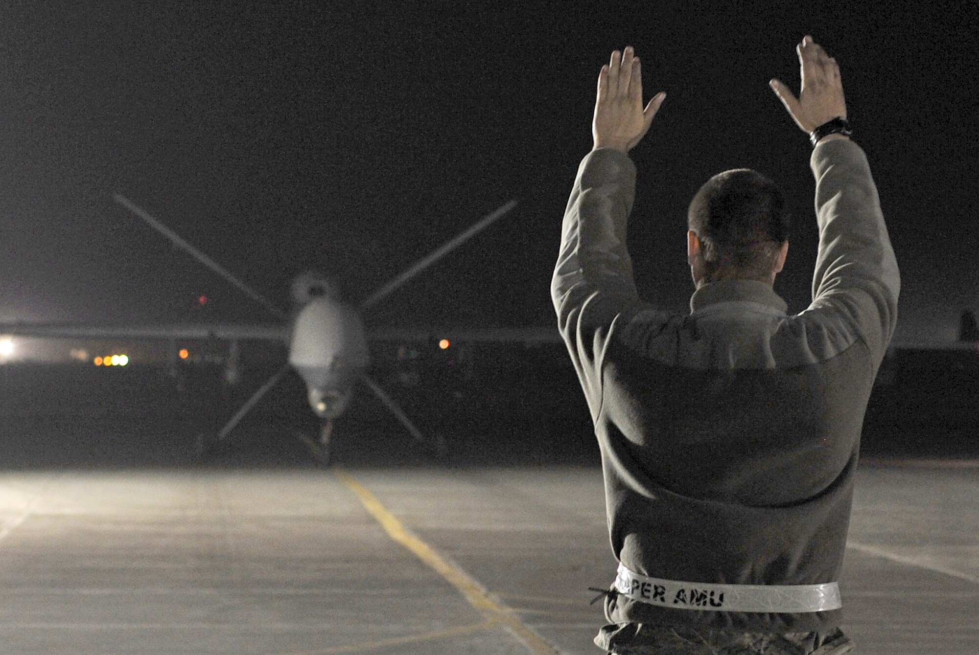 A staff sergeant marshalls an MQ-9 Reaper after it returned from a mission Dec. 1, 2010, at Kandahar Airfield, Afghanistan. (U.S. Air Force photo/Tech. Sgt. Chad Chisholm)
