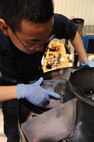 SEYMOUR JOHNSON AIR FORCE BASE, N.C. -- Senior Airman Jeffrey Jin checks the severity of a burn through on engine turbine exhaust strut here, Nov. 30, 2010. A burn through happens when a spark or excessive heat is pushed through small holes on either end of the strut causing the metal to melt. Airman Jin is a 4th Component Maintenance Squadron jet engine mechanic from Diamond Bar, Calif. (U.S. Air Force photo/Staff Sgt. Courtney Richardson)