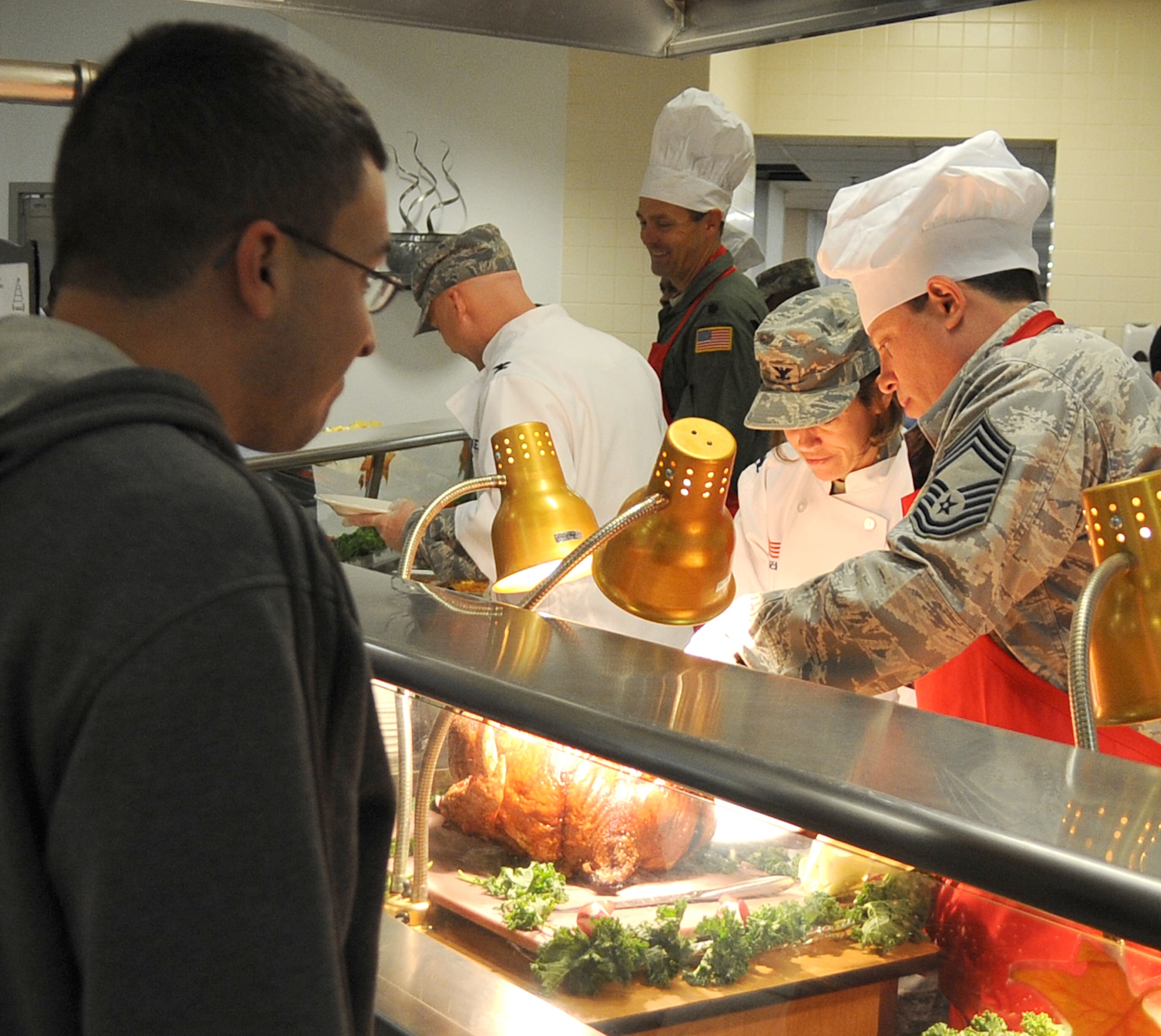 Joint base leadership serves turkey for an Airman in Halvorsen Hall, during a Thanksgiving meal Nov. 25, 2010.  The meal is held annually in observance of the holiday season to show appreciation to servicemembers to all the work they do throughout the year. (U.S. Air Force photo/1st Lt. Christine Darius)