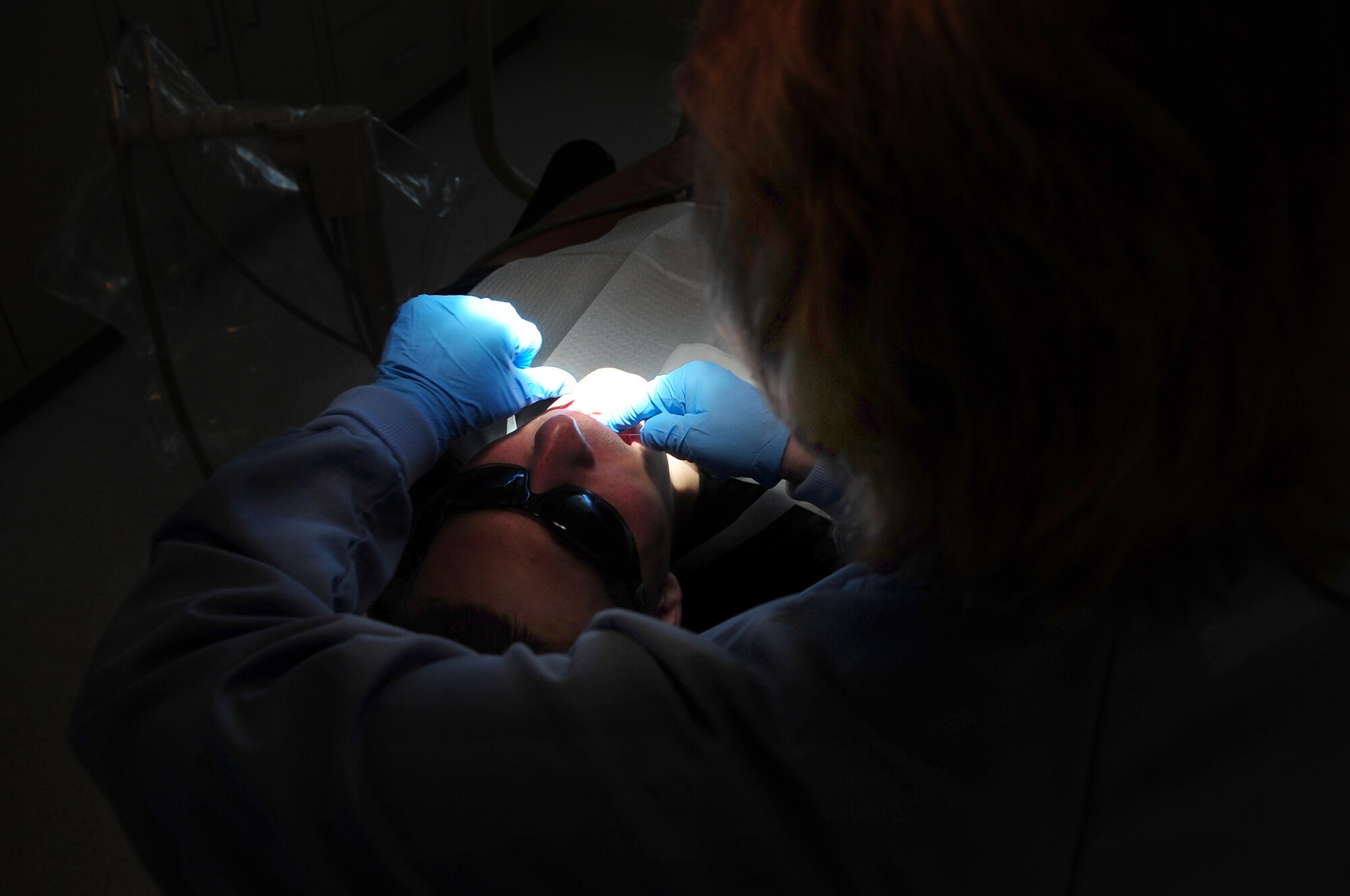 MOODY AIR FORCE BASE, Ga.-- Cindy Allen, 23rd Aeromedical Dental Squadron dental hygienist, flosses the teeth of Staff Sgt. William Strauss, 23rd Civil Engineer Squadron firefighter, Nov. 24. Flossing is one of the steps during dental routine cleansing at the dentist. (U.S. Air Force photo/Senior Airman Stephanie Mancha)(RELEASED)