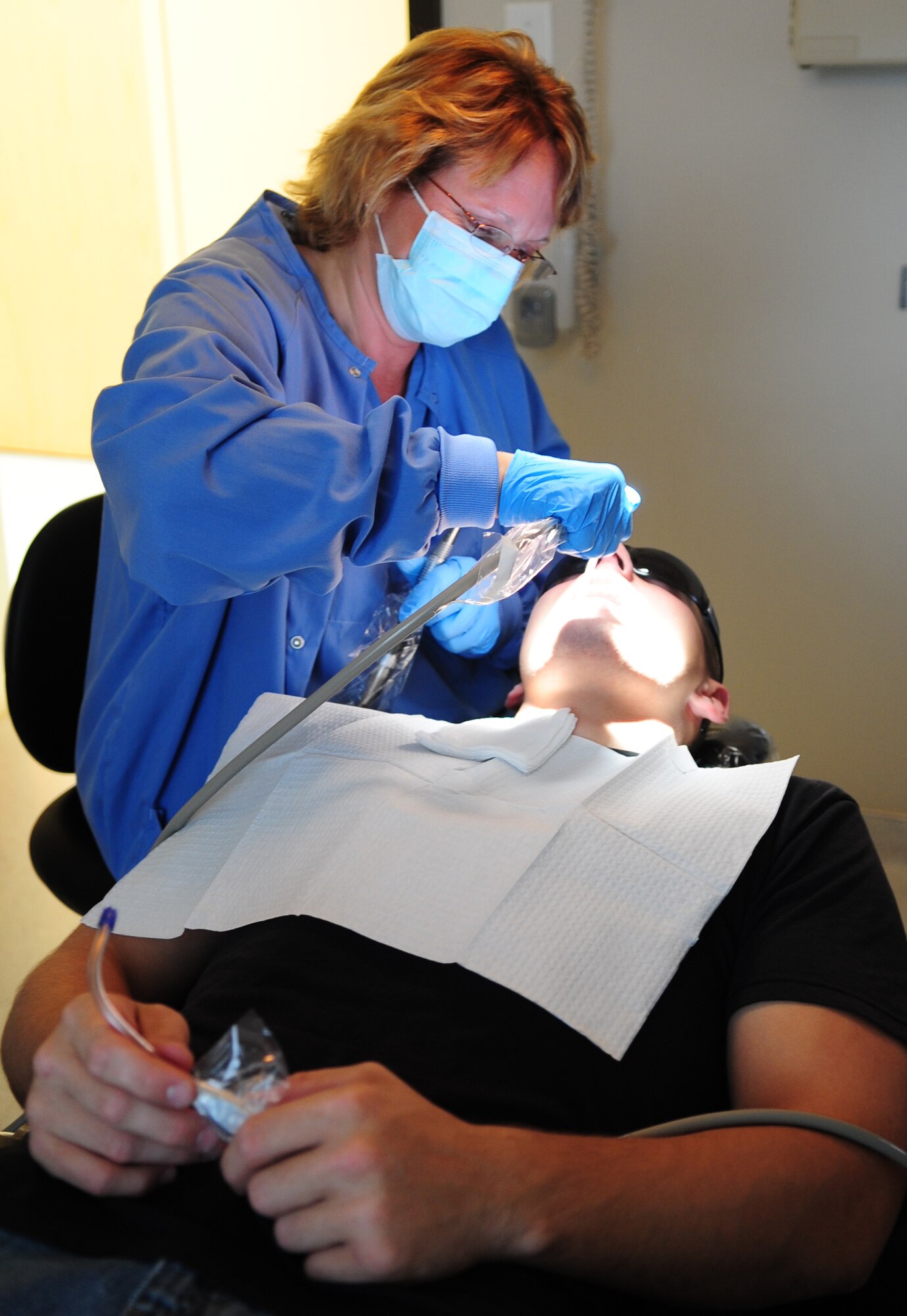 MOODY AIR FORCE BASE, Ga.-- Cindy Allen, 23rd Aeromedical Dental Squadron dental hygienist, rinses the mouth of Staff Sgt. William Strauss, 23rd Civil Engineer Squadron firefighter, with water Nov. 24. A dental routine cleanse is performed before the dentist can see a  patient. (U.S. Air Force photo/Senior Airman Stephanie Mancha)(RELEASED)