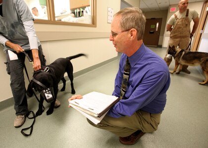 Dr. Walter Burghardt evaluates the behavior of a military working dog. Dr. Burghardt is the chief of Behavioral Medicine and Military Working Dog Studies at Lackland's Daniel E. Holland MWD Hospital. (U.S. Air Force photo/Robbin Cresswell)