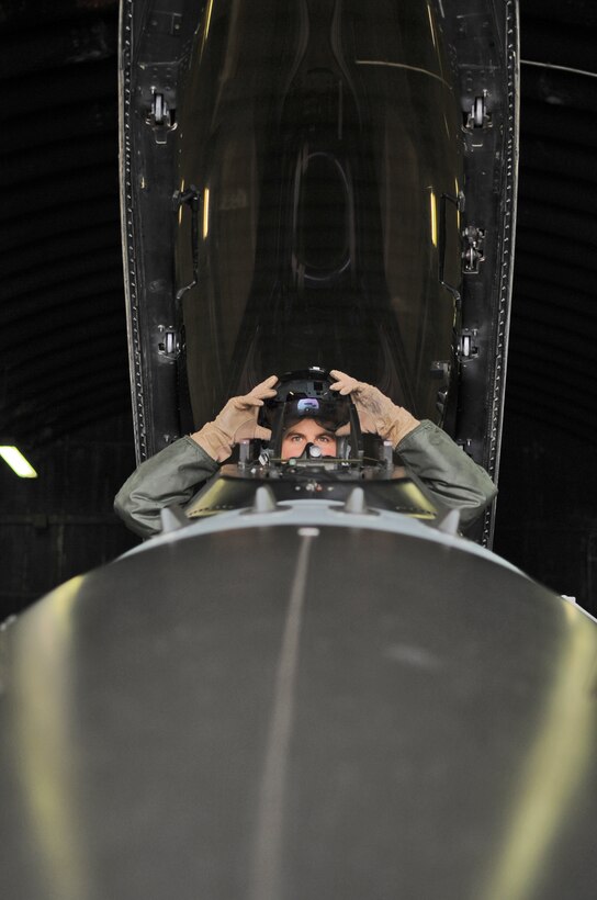 SPANGDAHLEM AIR BASE, Germany –Capt. Thomas Young, 480th Fighting Squadron F-16 Fighting Falcon pilot, puts his helmet on while performing a pre-flight inspection in the cockpit of an F-16 Dec. 2. Captain Young and five other pilots from the 480th FS have completed Allied Command Europe’s Tactical Leadership Program this year to move from flight lead of four aircraft to command a 30-ship force. (U.S. Air Force photo/Senior Airman Nick Wilson)