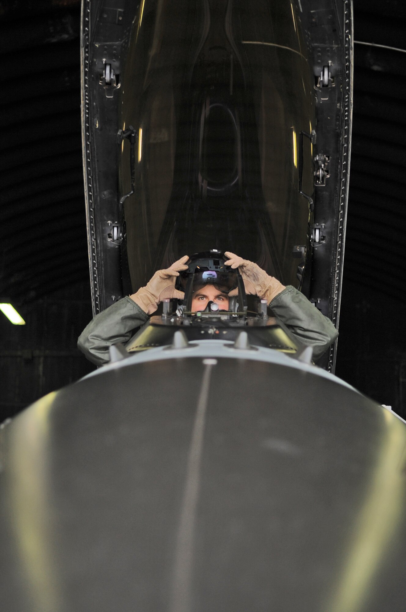 SPANGDAHLEM AIR BASE, Germany –Capt. Thomas Young, 480th Fighting Squadron F-16 Fighting Falcon pilot, puts his helmet on while performing a pre-flight inspection in the cockpit of an F-16 Dec. 2. Captain Young and five other pilots from the 480th FS have completed Allied Command Europe’s Tactical Leadership Program this year to move from flight lead of four aircraft to command a 30-ship force. (U.S. Air Force photo/Senior Airman Nick Wilson)