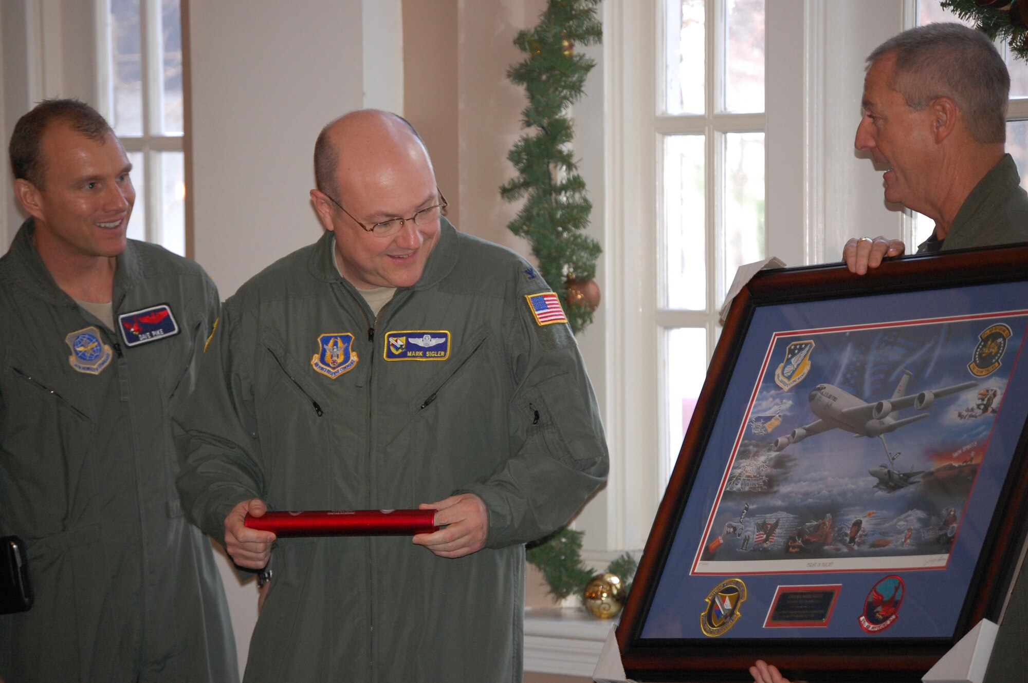 Lt. Cols. David Pike (left), 911th Air Refueling Squadron director of operations and Brian Davis, 77th Air Refueling Squadron director of operations, present Lt. Col. Mark Sigler (center) with a memento of the flying ops upon his departure from the 916th Air Refueling Wing (USAF photo by Maj. Shannon Mann, 916PA)