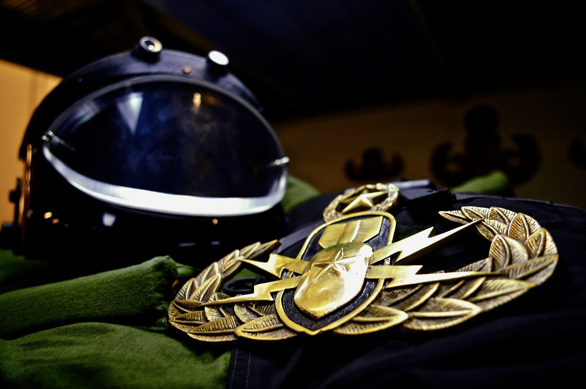 An enlarged U.S. Air Force Explosive Ordinance Disposal career field badge sits atop an EOD bomb suit and helmet on Ramstein. (Photo by 2nd Lt. Christopher Diaz)