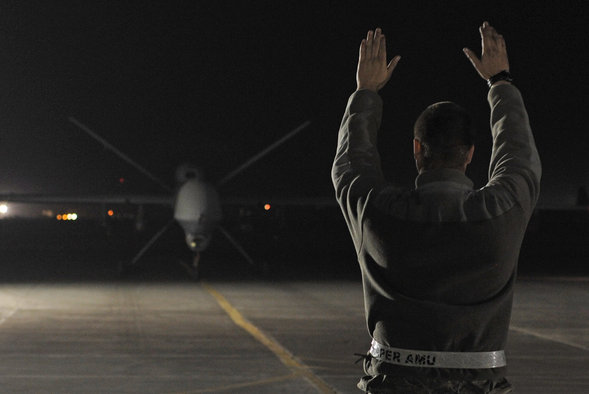 Staff Sgt. Justin marshalls an MQ-9 Reaper after it returned Kandahar Airfield, Afghanistan, from a mission Dec. 1, 2010. Airmen accepted control of the MQ-9 maintenance operations this day making them the first military members to work on the aircraft for Operation Enduring Freedom in Afghanistan. Sergeant Justin, from Creech Air Force Base, Nev., is a tactical aircraft maintenance craftsman assigned to the 451st Expeditionary Aircraft Maintenance Squadron MQ-9 Aircraft Maintenance Unit. (U.S. Air Force photo by Tech. Sgt. Chad Chisholm/Released)