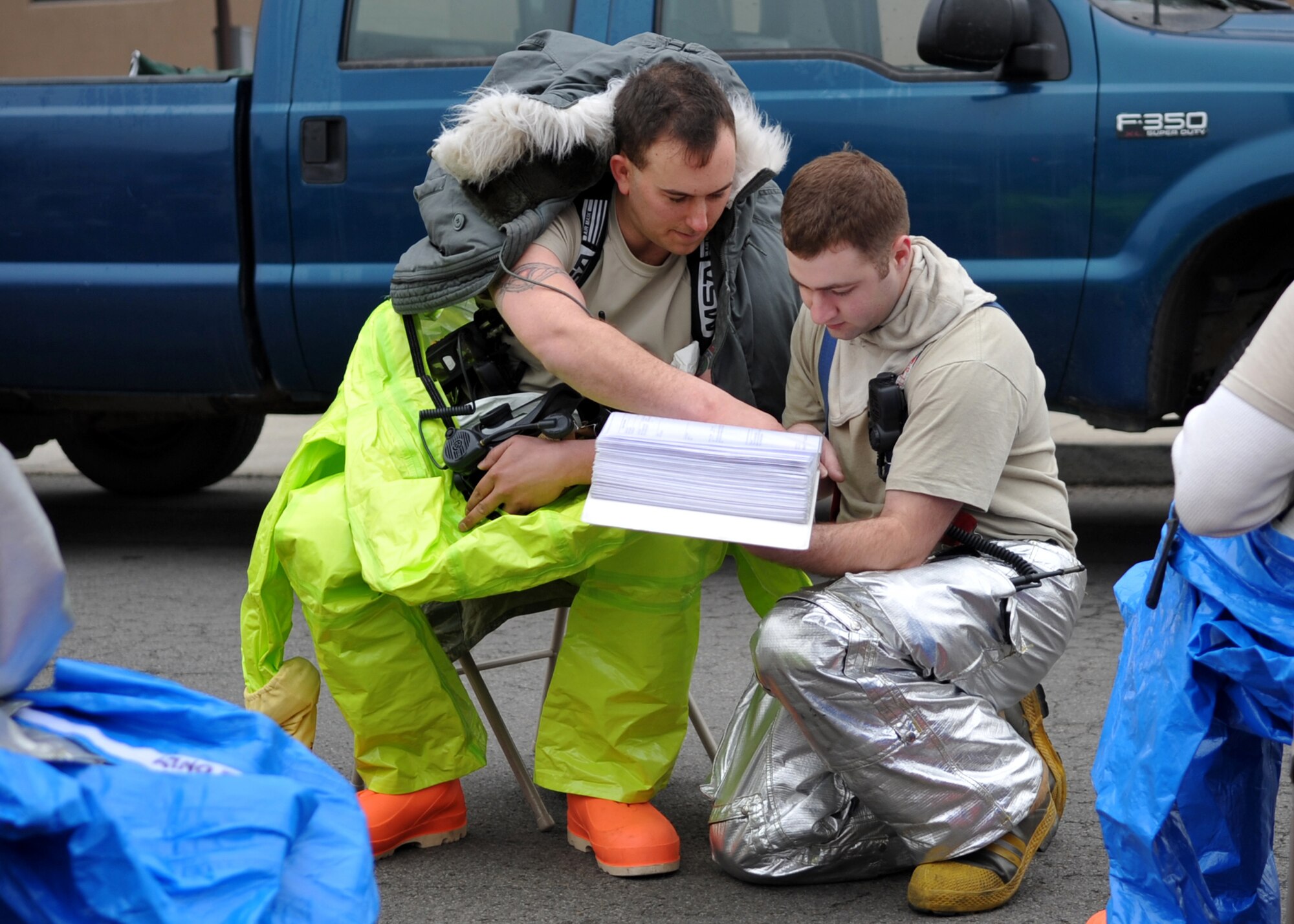 (L-R) Staff Sgt. Casey Love, 51st Civil Engineer Squadron, review plans to enter a "contaminated room" during an Emergency Management Exercise Dec. 1.  The exercise included a simulated biological attack where a hostile Airman planted a device in the HVAC system of a dorm building to disperse aerosolized botulism. The exercise was designed to evaluate emergency responders and search and recovery efforts. (U.S. Air Force Photo /Senior Airman Evelyn Chavez)