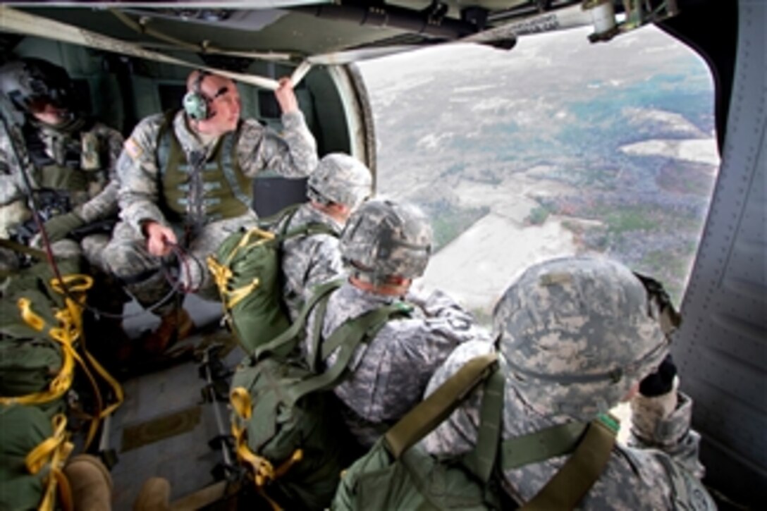 U.S. Army Staff Sgt. David Harp prepares paratroopers with 1st Brigade Combat Team to jump from a UH-60M Black Hawk helicopter at Fort Bragg, N.C., on Nov. 29, 2010.  Harp, the noncommissioned officer in charge of airborne operations, is assigned to the 82nd Airborne Division's 2nd Battalion, 325th Airborne Infantry Regiment, 2nd Brigade Combat Team.  