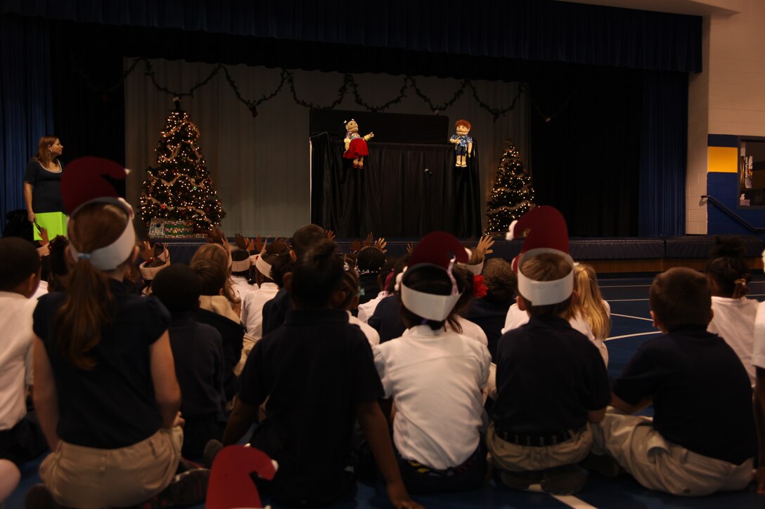 Havelock Elementary School students watch a puppet show performed by members of Marine Corps Family Team Building during a holiday celebration with Cherry Point Marines in the school’s gymnasium, Dec. 3.