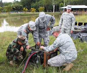 SOTO CANO AIR BASE, Honduras - Soldiers and Airmen from Joint Task Force-Bravo work on assembling a pump that would be used at a Forward Air Refueling Point.  FARP assembly training was part of a two-day exercise that included water purification.  JTF-B conducted the exercise at Fuerte General Hogar De Los in Siguatepeque, Honduras. (photo by Tech. Sgt. Edward Roldan)