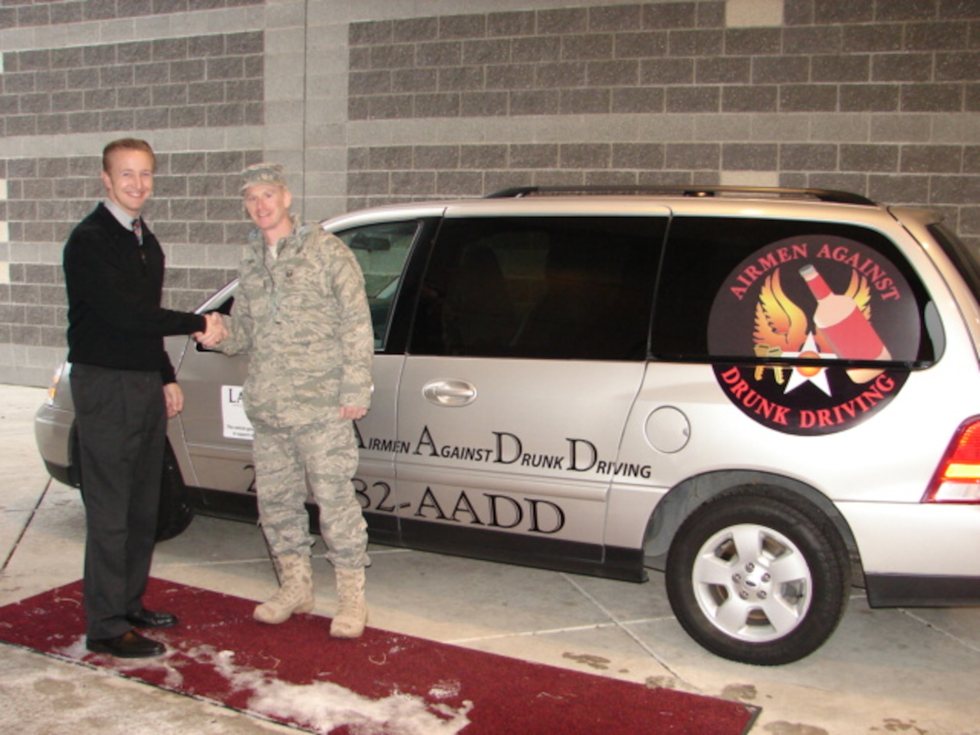 Master Sgt. Phillip Ryan, right, 62nd Airlift Wing Airmen Against Drunk Driving president, shakes hands with Greg Anderson, Lakewood Ford salesman, after receiving the McChord Field, Wash., AADD van Dec. 2 in Lakewood, Wash. The van will be utilized by volunteers to ensure Team McChord residents get home safely. AADD’s mission is to provide free, safe, confidential rides to those who have been drinking and make the responsible decision to let someone else do the driving. To contact AADD, dial (253) 982 - AADD. (U.S. Air Force courtesy photo)
