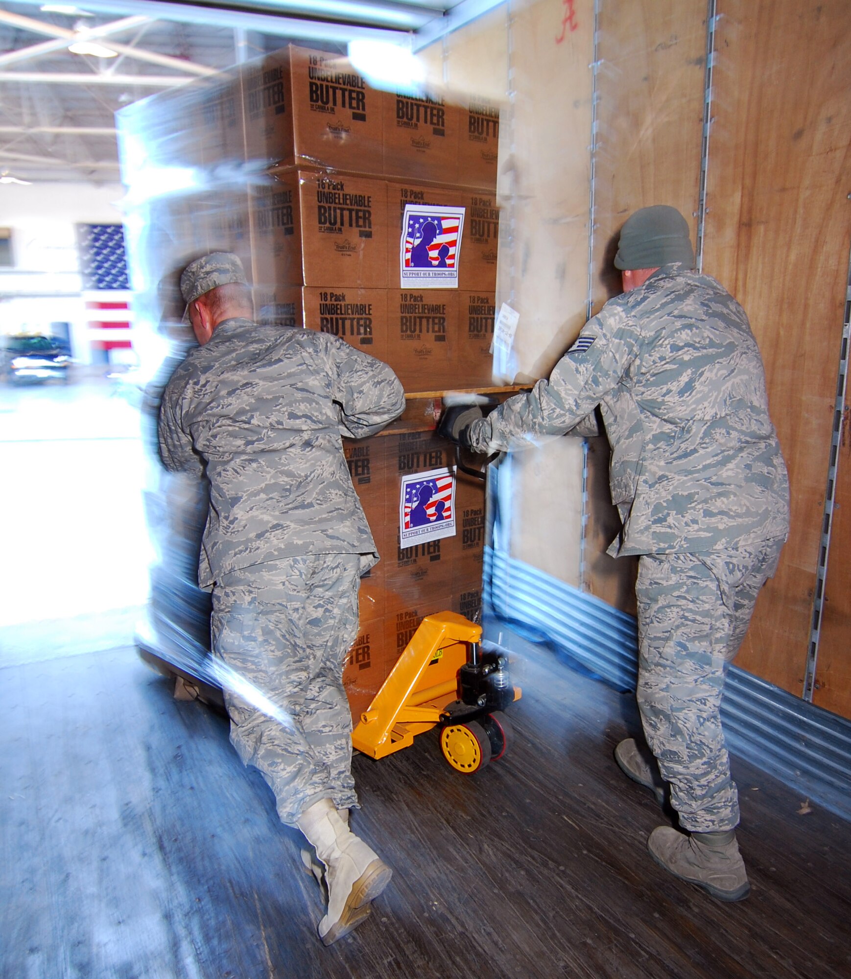 TSgt Dallas Criswell and SSgt David Autenrieth maneuver a pallet of popcorn into position for offloading by forklift Dec 3.   Both Airmen are with the 94th Aerial Delivery Flight at Dobbins Air Reserve Base, Ga. and are receiving a shipment of popcorn collected by Atlanta area Boy Scouts of America for donation to military members working at the base.   (U.S. Air Force photo/ Brad Fallin)