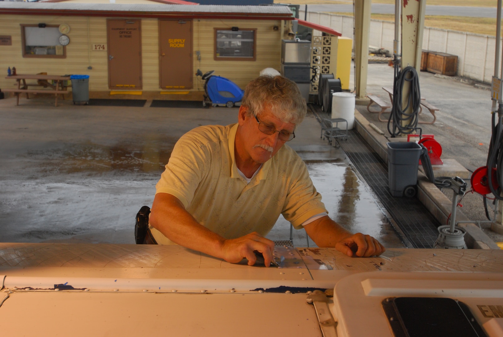 RANDOLPH AIR FORCE BASE, Texas -- Kirk Mason, 902nd Logistics Readiness Squadron vehicle control operations, removes adhesive graphics from a school bus.  902nd LRS vehicle control operations manages and serves just about every kind of vehicle one can think of on base, except boats or aircraft. They handle base bussed, taxis, government sedans, construction equipment and more. 

“Most people think of the base taxi and supporting [distinguished visitors], but that’s just a small part of it,” said Michael Cox, 902nd Logistics Readiness Squadron vehicle control operations supervisor while walking through a yard with school busses, sedans, forklifts, box trucks, multi-passenger vans – all spotless and parked neatly.”We do more than taxis, it’s quite diverse.” (U.S. Air Force photo/Brian McGloin)
