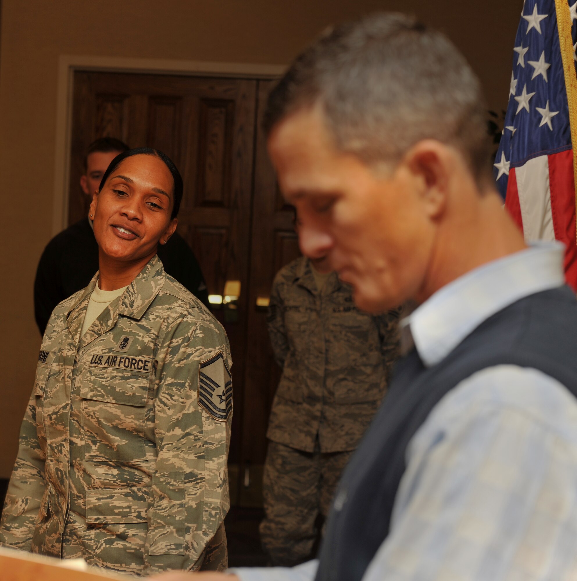 MOODY AIR FORCE BASE, Ga.-- Master Sgt. Matilda Mahone, 23rd Medical Support Squadron pharmacy flight chief, looks towards Chief Master Sgt. Richard Parsons, 23rd Wing command chief, while he opens a gift during his going-away luncheon Dec. 3. Airmen from different agencies around base were provided the opportunity to giving parting gifts to Chief Parsons and his family. (U.S. Air Force photo/Airman 1st Class Joshua Green)(RELEASED)
