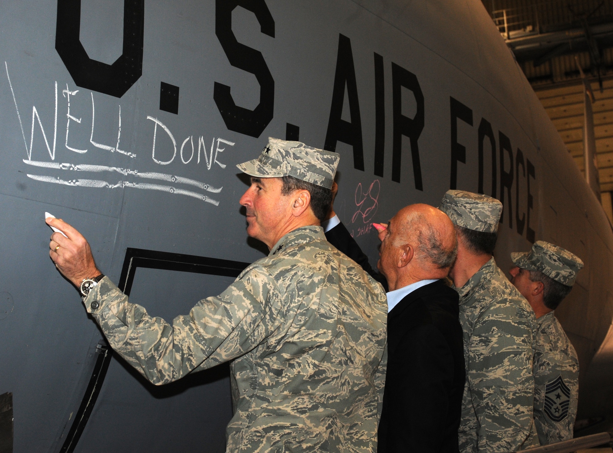 Gen. Raymond Johns (from left to right), Air Mobility Command commander, John Marshall, Grand Forks Air Force Base ambassador, Col. Don Shaffer, 319th Air Refueling Wing commander and Chief Master Sgt. David Spector, AMC command chief, sign the last KC-135 Stratotanker stationed here, after the conclusion of the mission complete ceremony Dec. 3. The ceremony was held to recognize the completion of 50 years of KC-135 Stratotanker flight and maintenance operations on base. Grand Forks Air Force Base is scheduled to receive Global Hawks in the summer of 2011. (U.S. Air Force photo by Tech. Sgt. Johnny Saldivar)