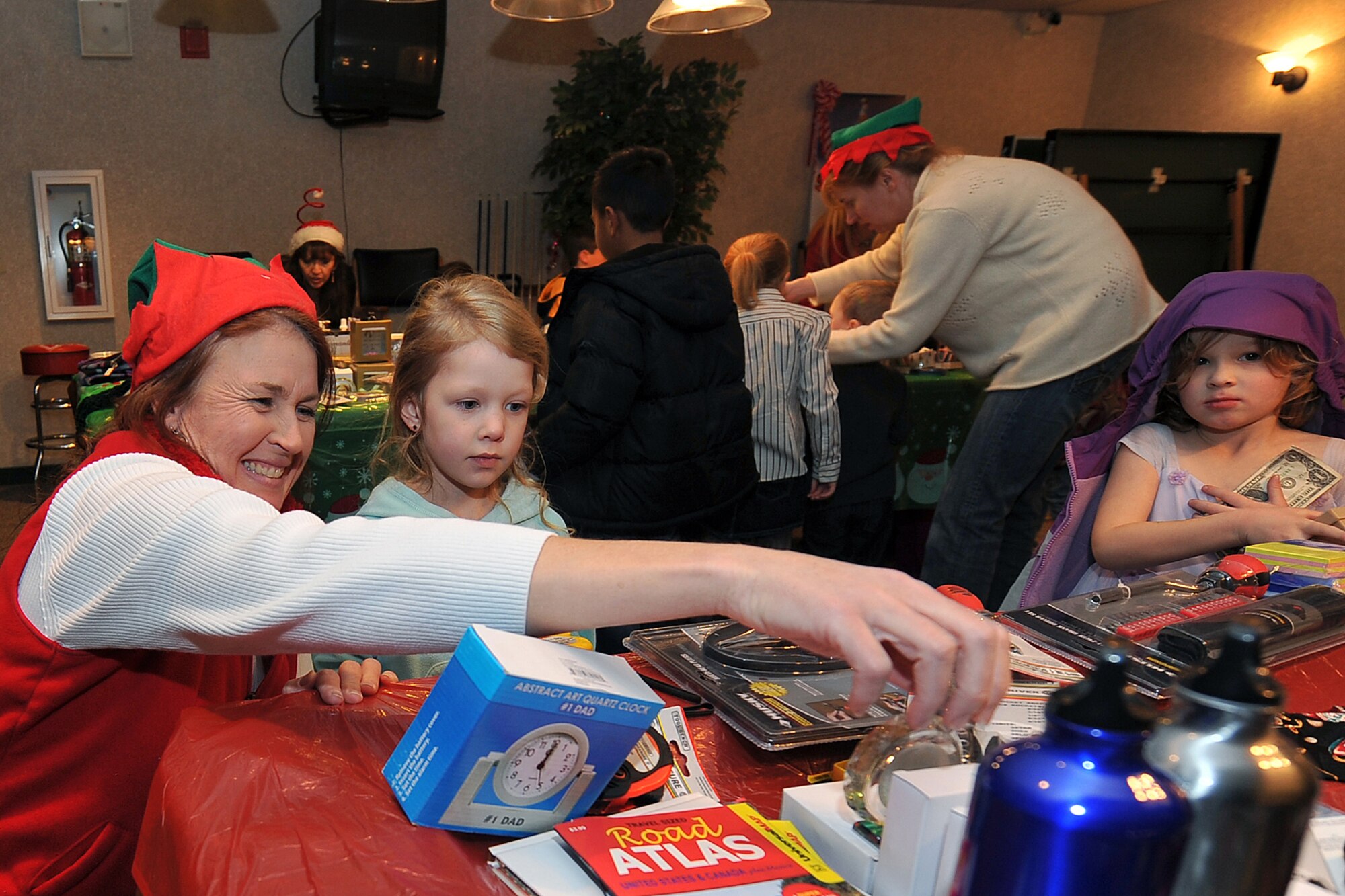 OFFUTT AIR FORCE BASE, Neb. - Laura Shanahan, wife of the 55th Wing commander Brig. Gen. John N.T. Shanahan, helps Carley Powers pick out a gift for her father Staff Sgt. Brian Powers, 55th Civil Engineering Squadron, during the tree lighting and holiday events inside the Community Activity Center Dec. 02. This annual event provides Team Offutt member and their families a fun environment to share their joy and give presents to their love ones this Christmas season.  U.S. Air Force Photo by Charles Haymond